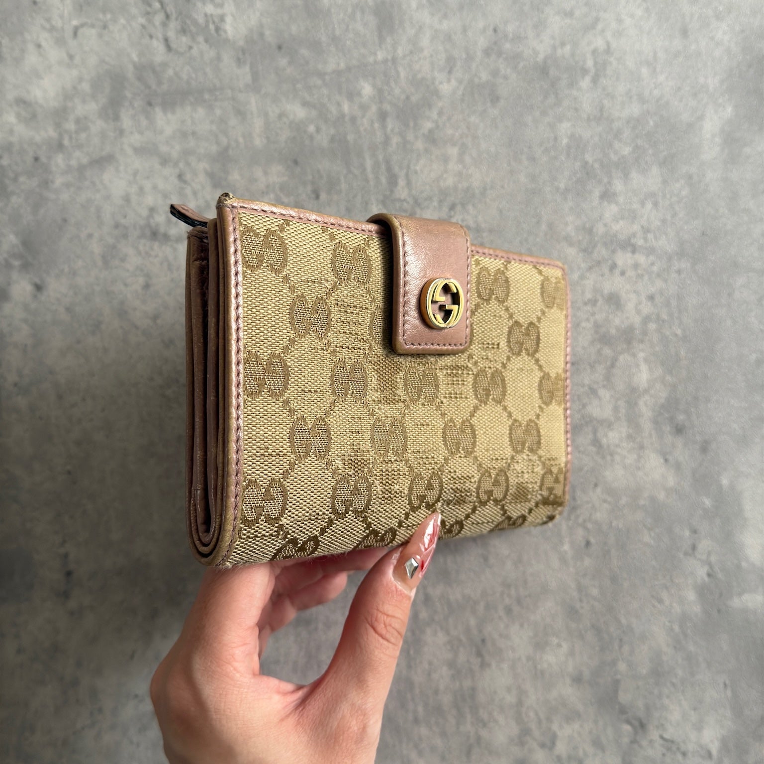 Gucci GG Logo Canvas Bifold Wallet in Pink/Beige with snap closure and multiple compartments, displaying minimal signs of wear.