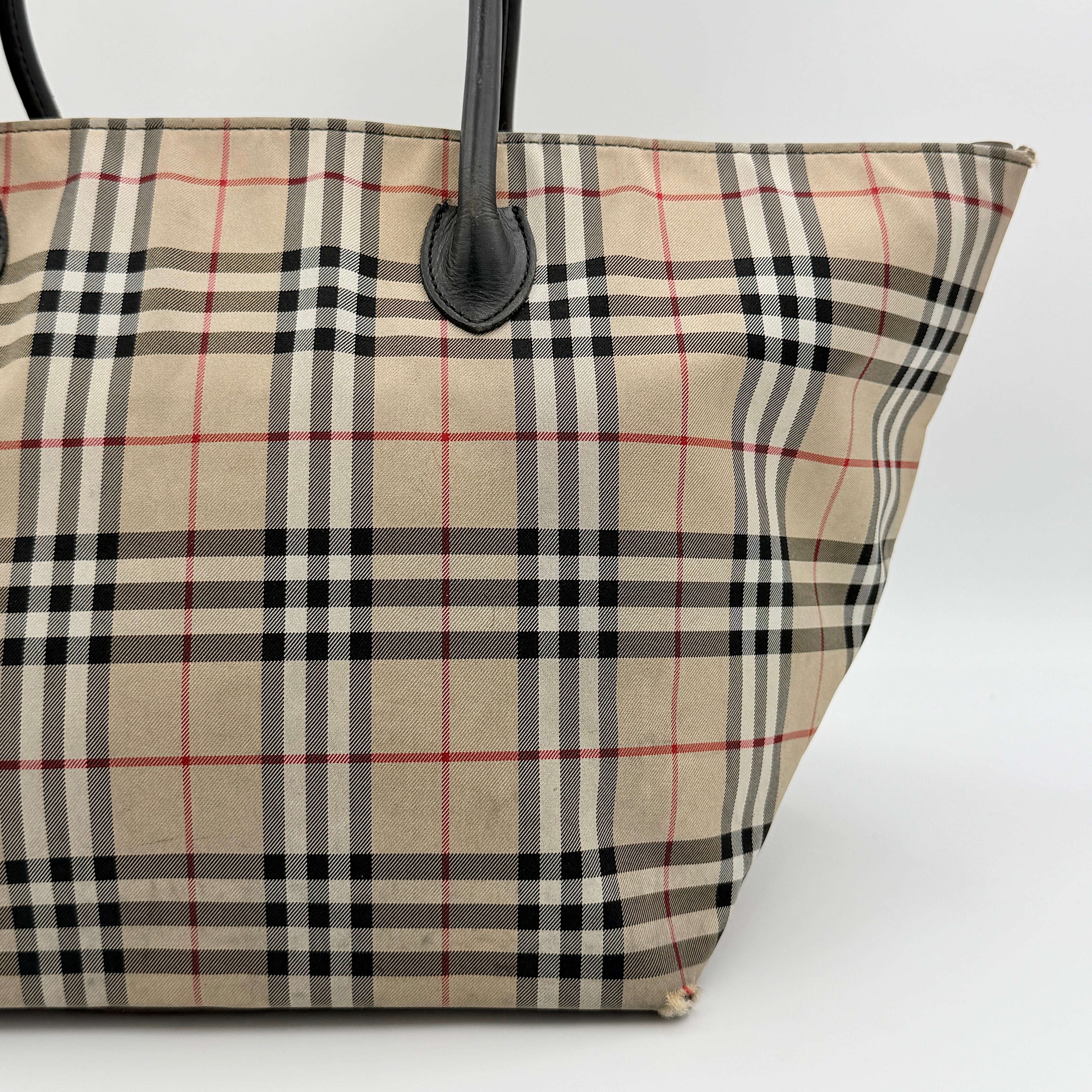 Burberry Nova Check shoulder bag in beige and black with black leather handles and zip closure.