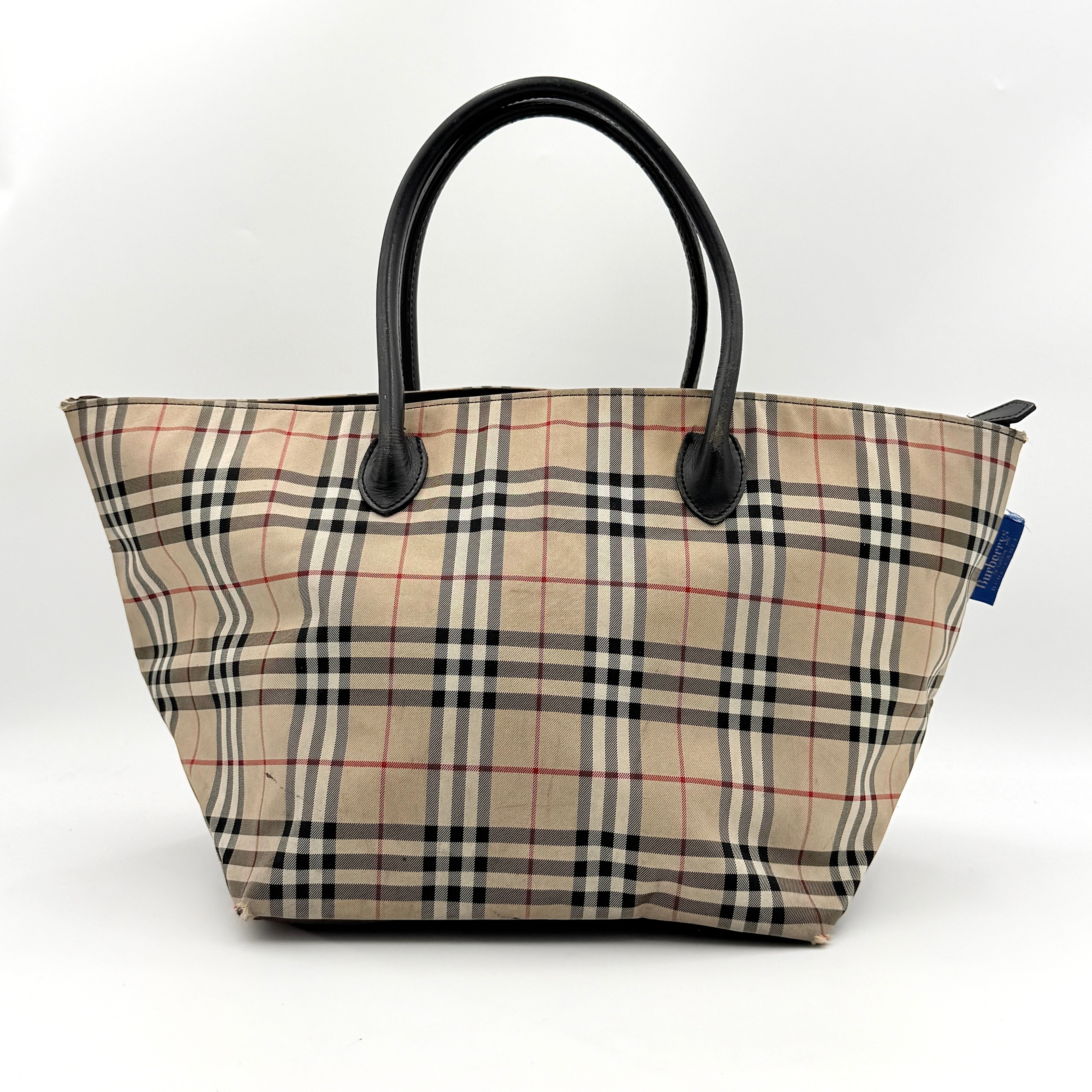 Burberry Nova Check shoulder bag in beige and black with black leather handles and zip closure.