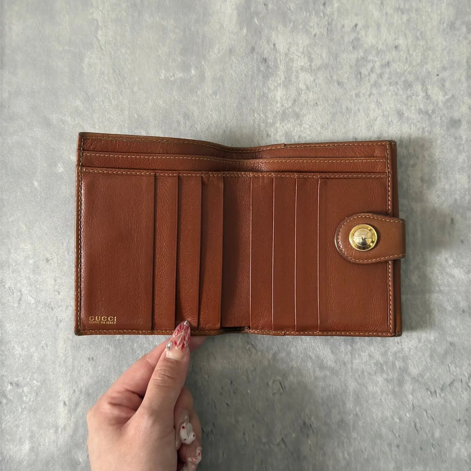 Gucci Signature Logo Clip Vintage Brown Wallet, crafted from smooth brown leather with a gold-tone logo clip.