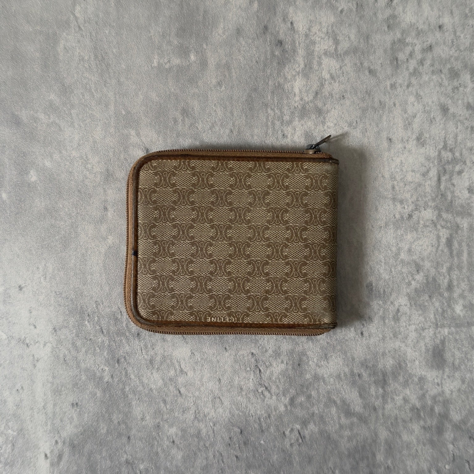 Celine Signature Macadam Triomphe Wallet in beige canvas with brown leather details, featuring multiple organizational compartments, embodying classic elegance and functionality.