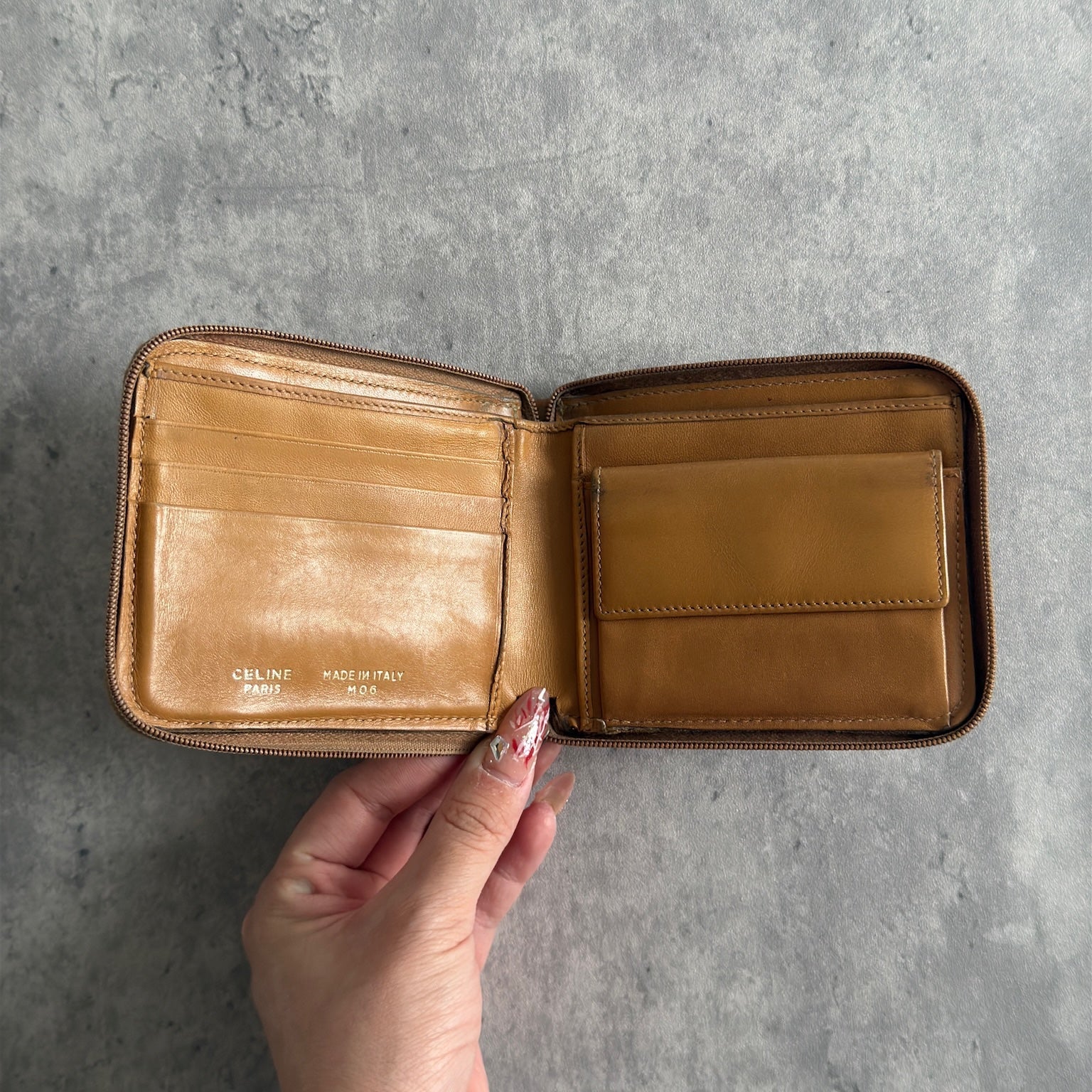 Celine Signature Macadam Triomphe Wallet in beige canvas with brown leather details, featuring multiple organizational compartments, embodying classic elegance and functionality.