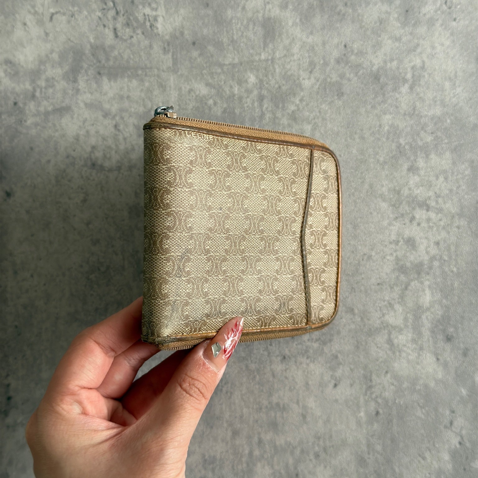 Celine Signature Macadam Triomphe Wallet in beige canvas with brown leather details, featuring multiple organizational compartments, embodying classic elegance and functionality.