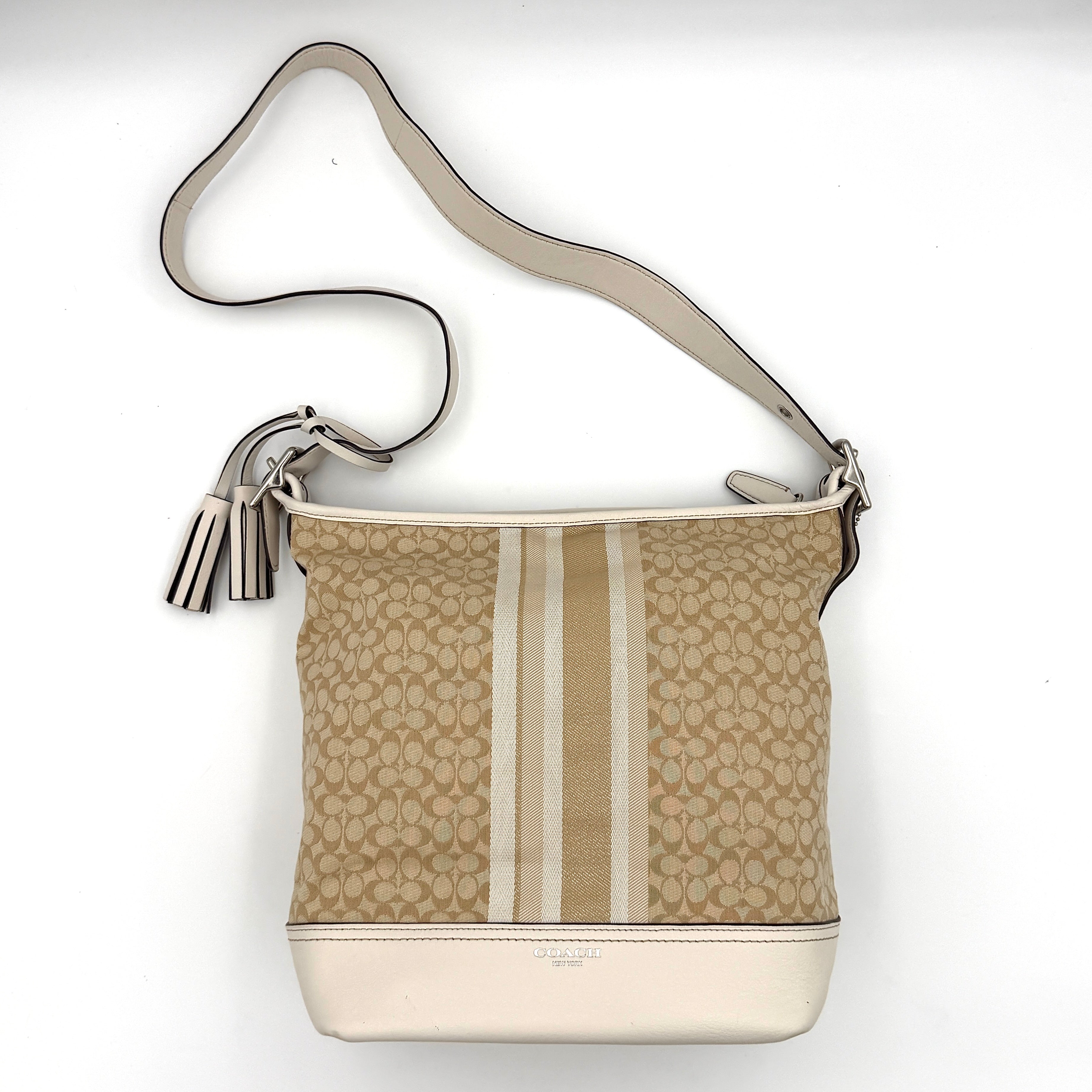 Coach Signature Stripe Duffle Legacy Crossbody Bag in khaki and cream with monogram pattern, central stripe, and adjustable leather strap.