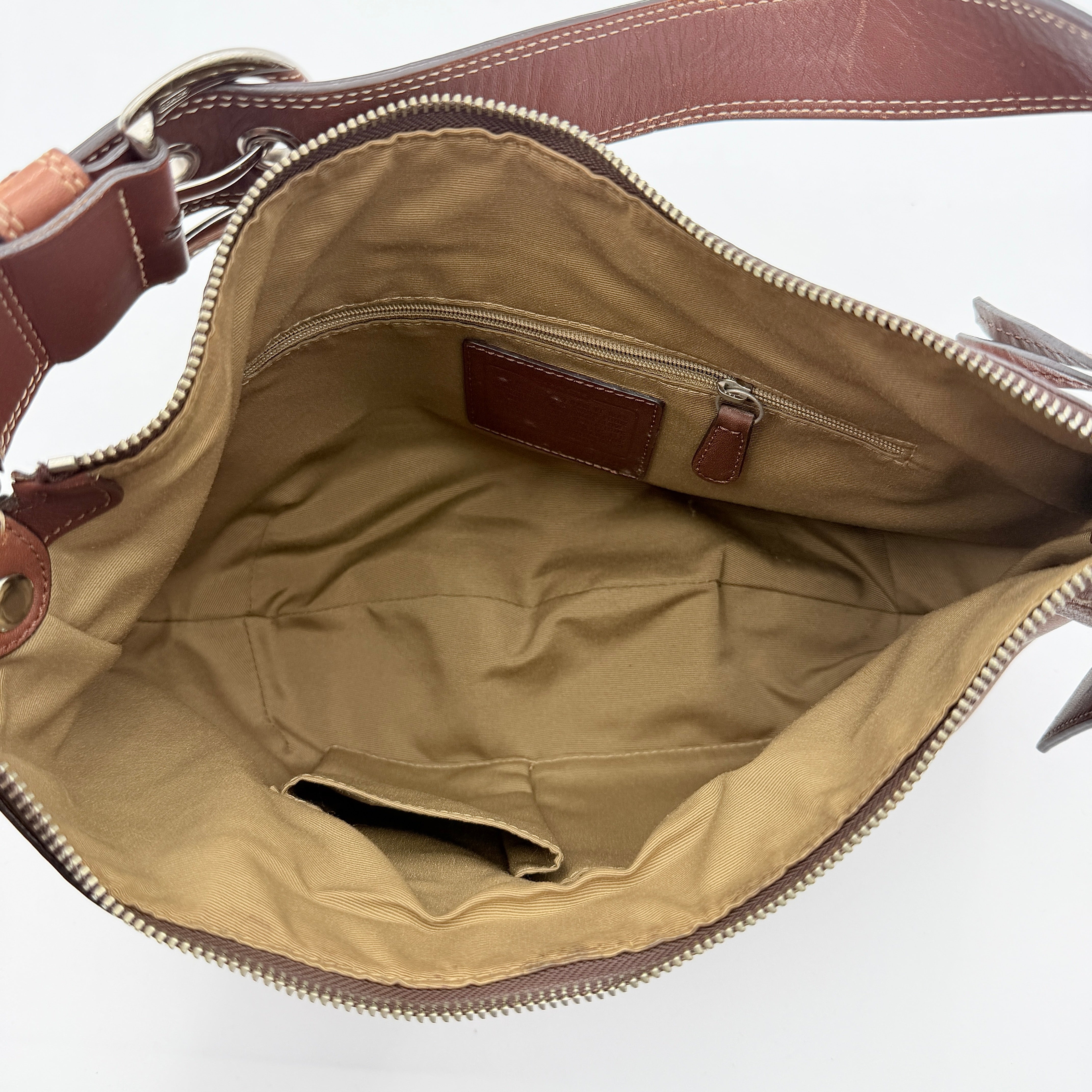 Coach Soho Hobo brown leather shoulder bag with pleated detailing and silver hardware, shown on a white background.