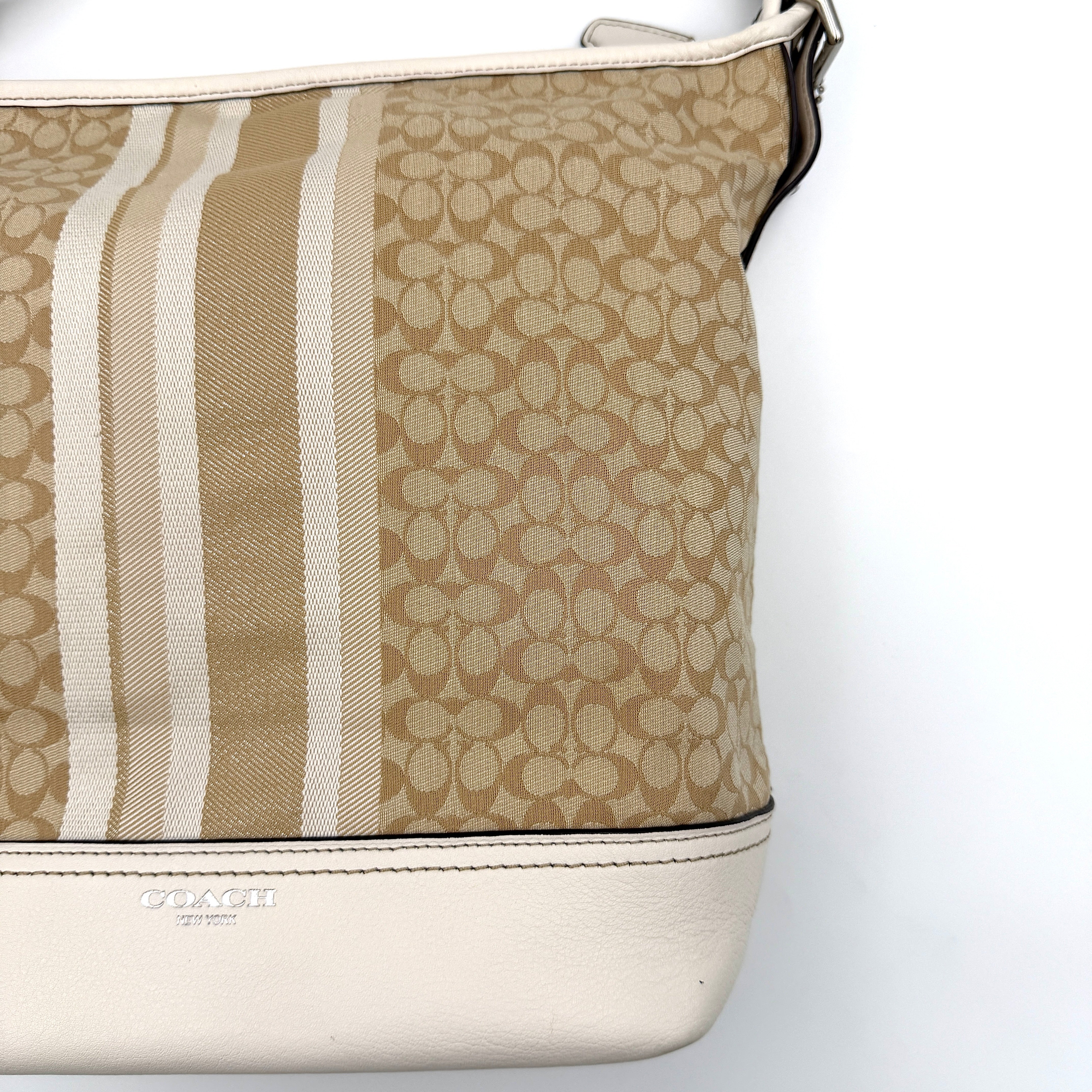 Coach Signature Stripe Duffle Legacy Crossbody Bag in khaki and cream with monogram pattern, central stripe, and adjustable leather strap.