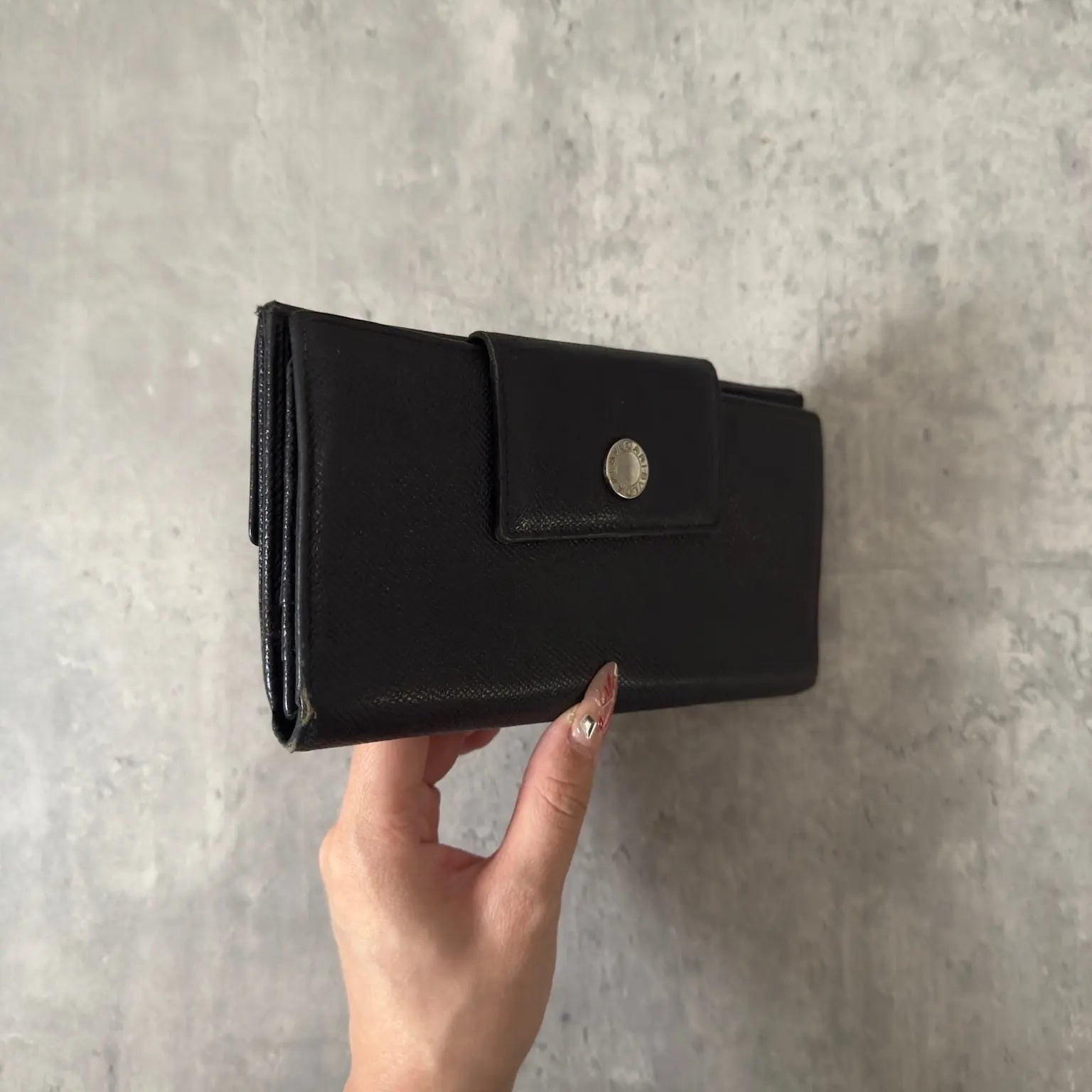 Bvlgari Classico Long Wallet in black leather, featuring a silver-tone logo clasp, multiple card slots, and a spacious bill compartment, showcasing understated luxury and sophistication.