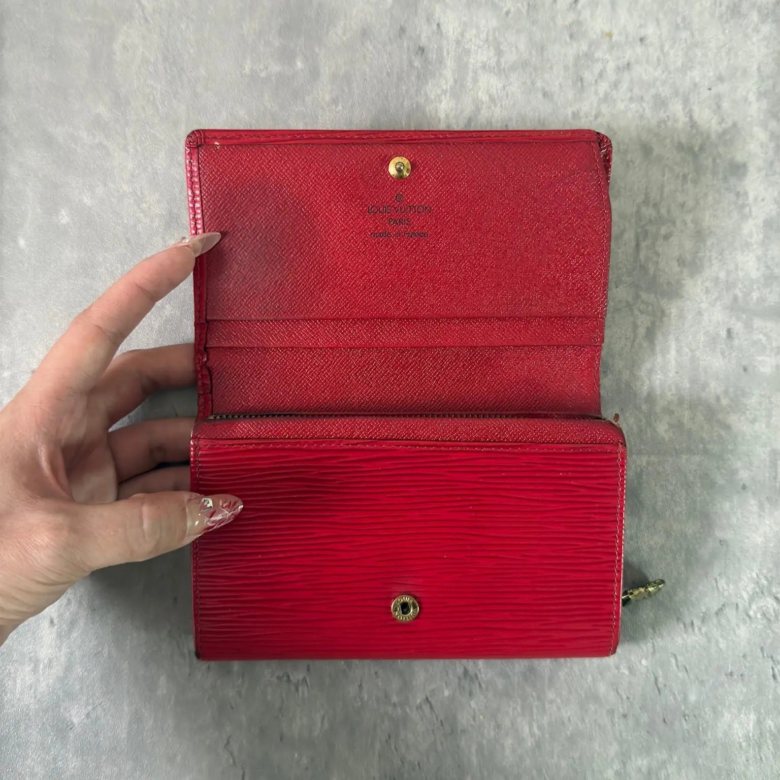 Louis Vuitton International Wallet in red Epi leather, featuring embossed LV logo, textured surface, multiple card slots, and gold-tone hardware. Compact and elegant, perfect for daily use.