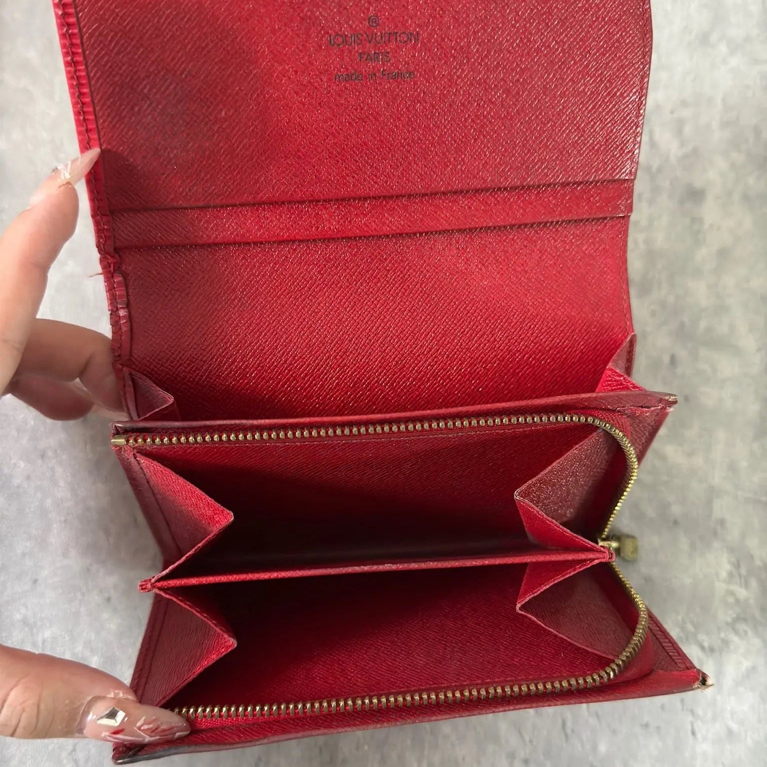 Louis Vuitton International Wallet in red Epi leather, featuring embossed LV logo, textured surface, multiple card slots, and gold-tone hardware. Compact and elegant, perfect for daily use.