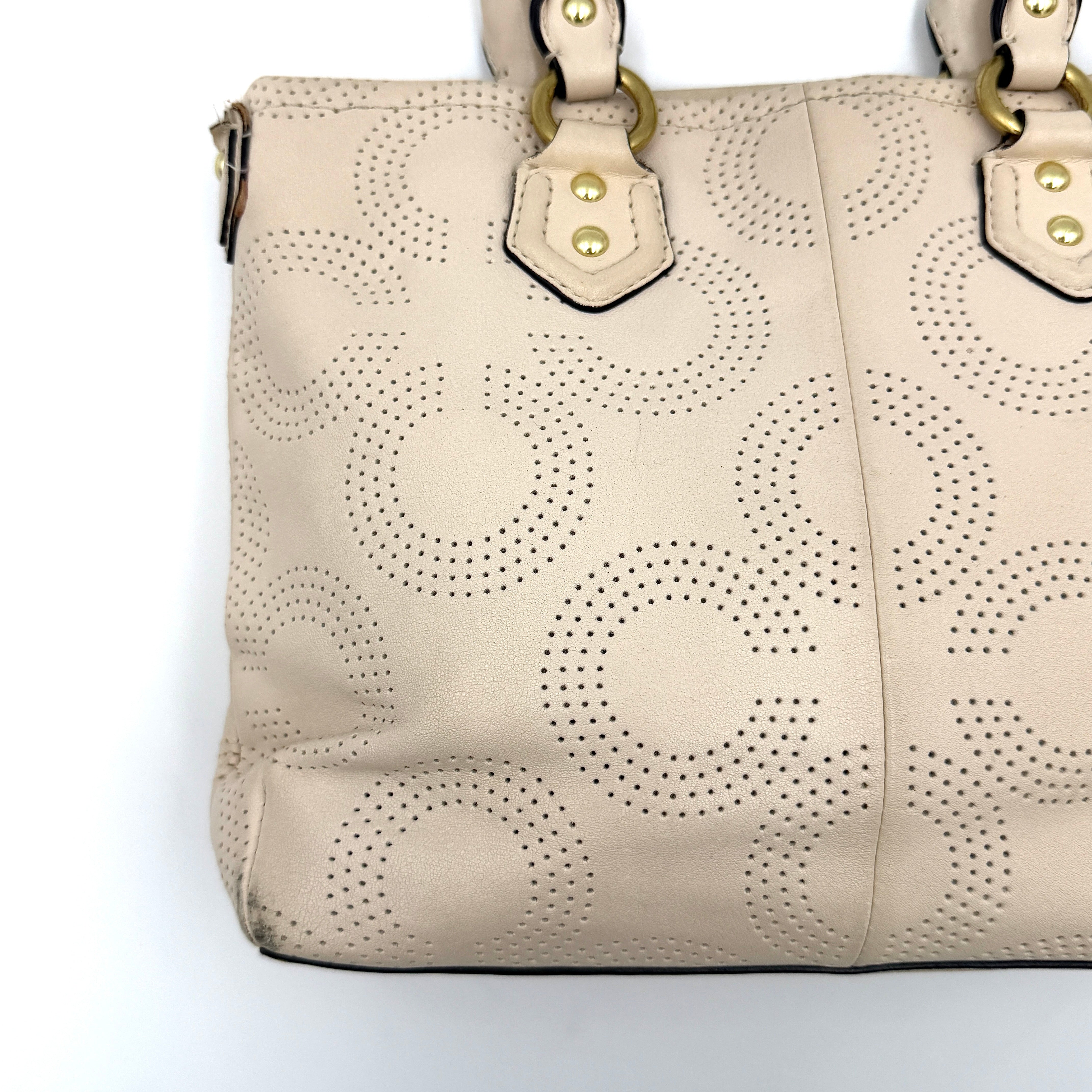Coach Ashley 2Way cream perforated Op Art leather handbag with dual handles and detachable strap, styled on a white background.