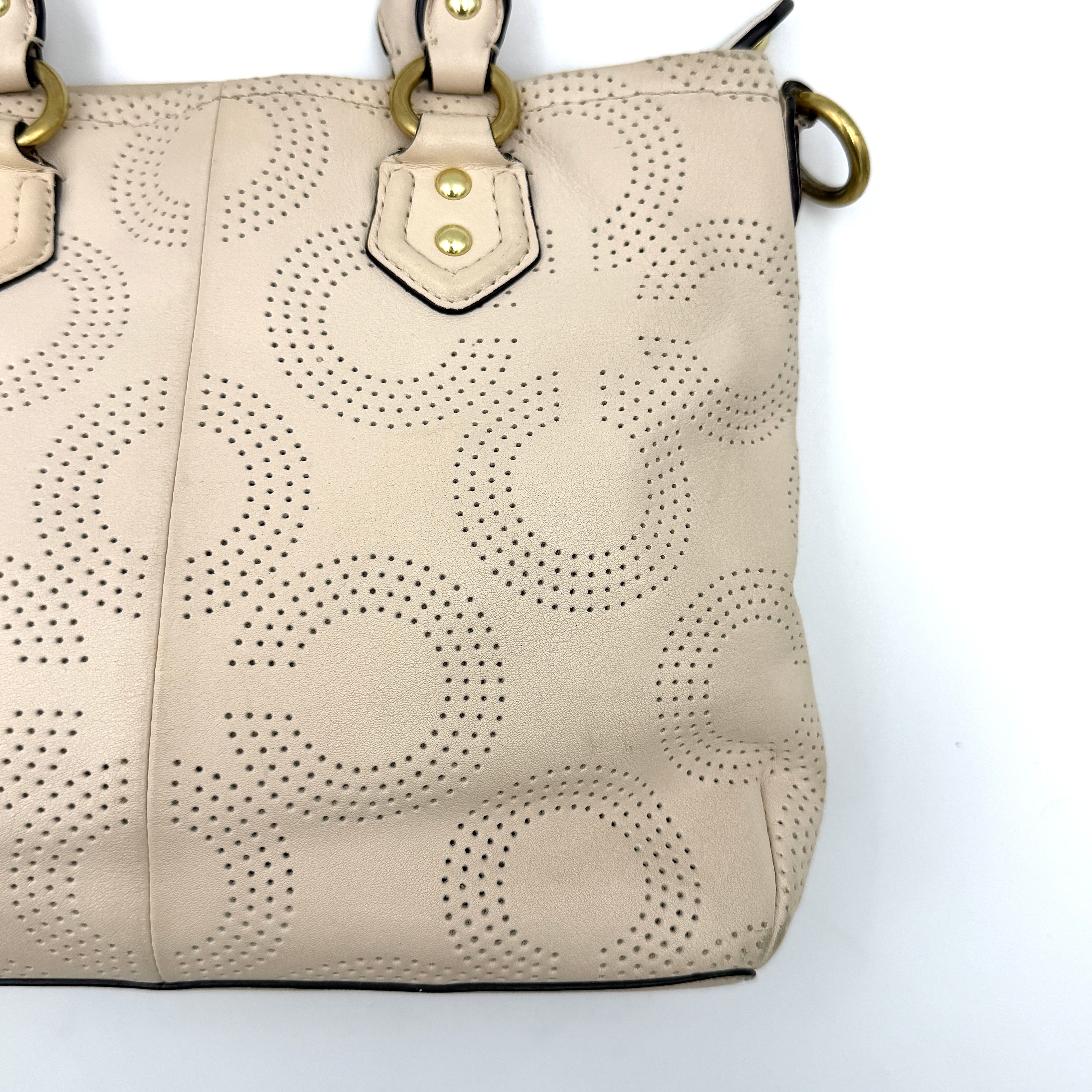 Coach Ashley 2Way cream perforated Op Art leather handbag with dual handles and detachable strap, styled on a white background.