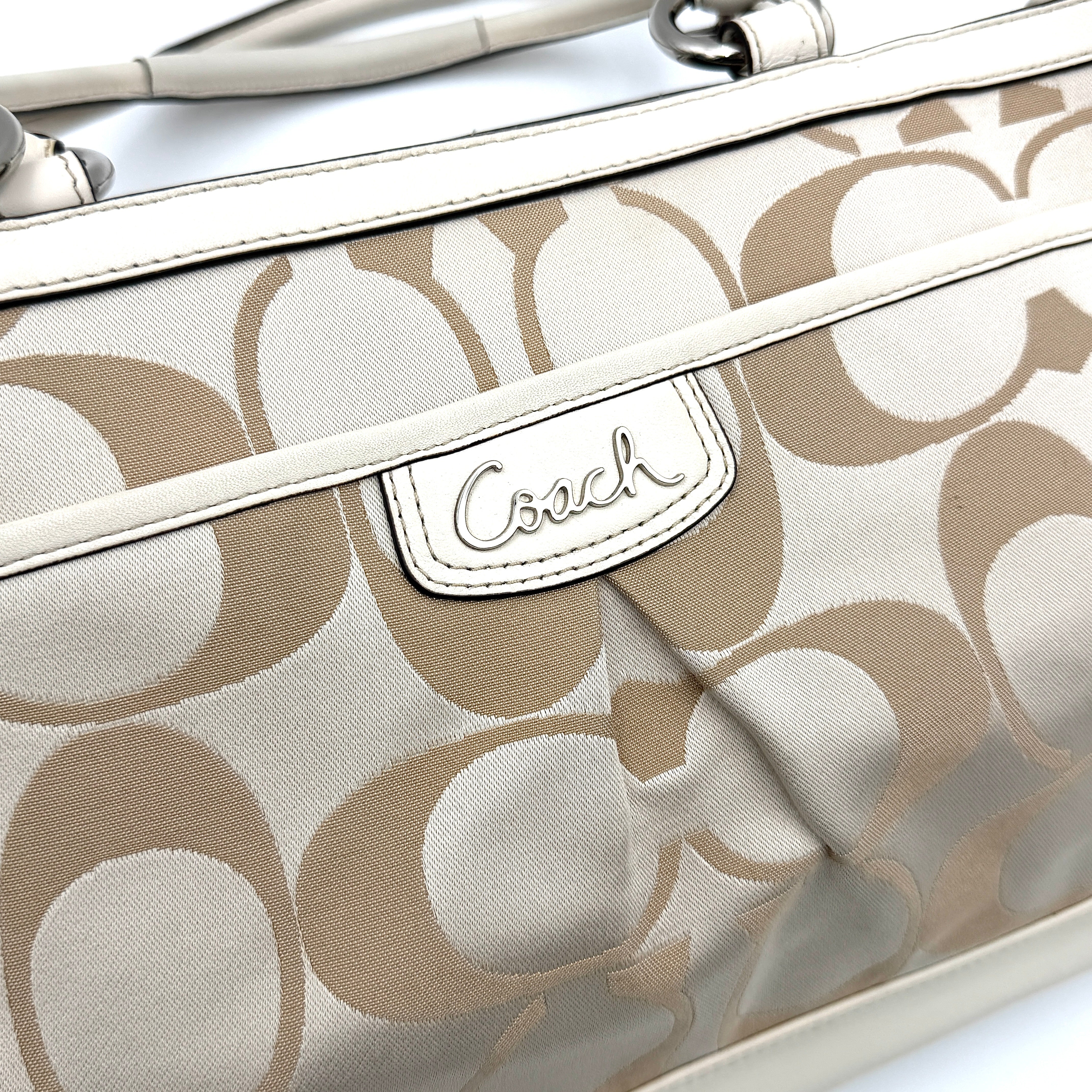 Coach Signature Carryall Shoulder Bag in beige jacquard canvas with cream leather trim and silver hardware displayed against a white background.