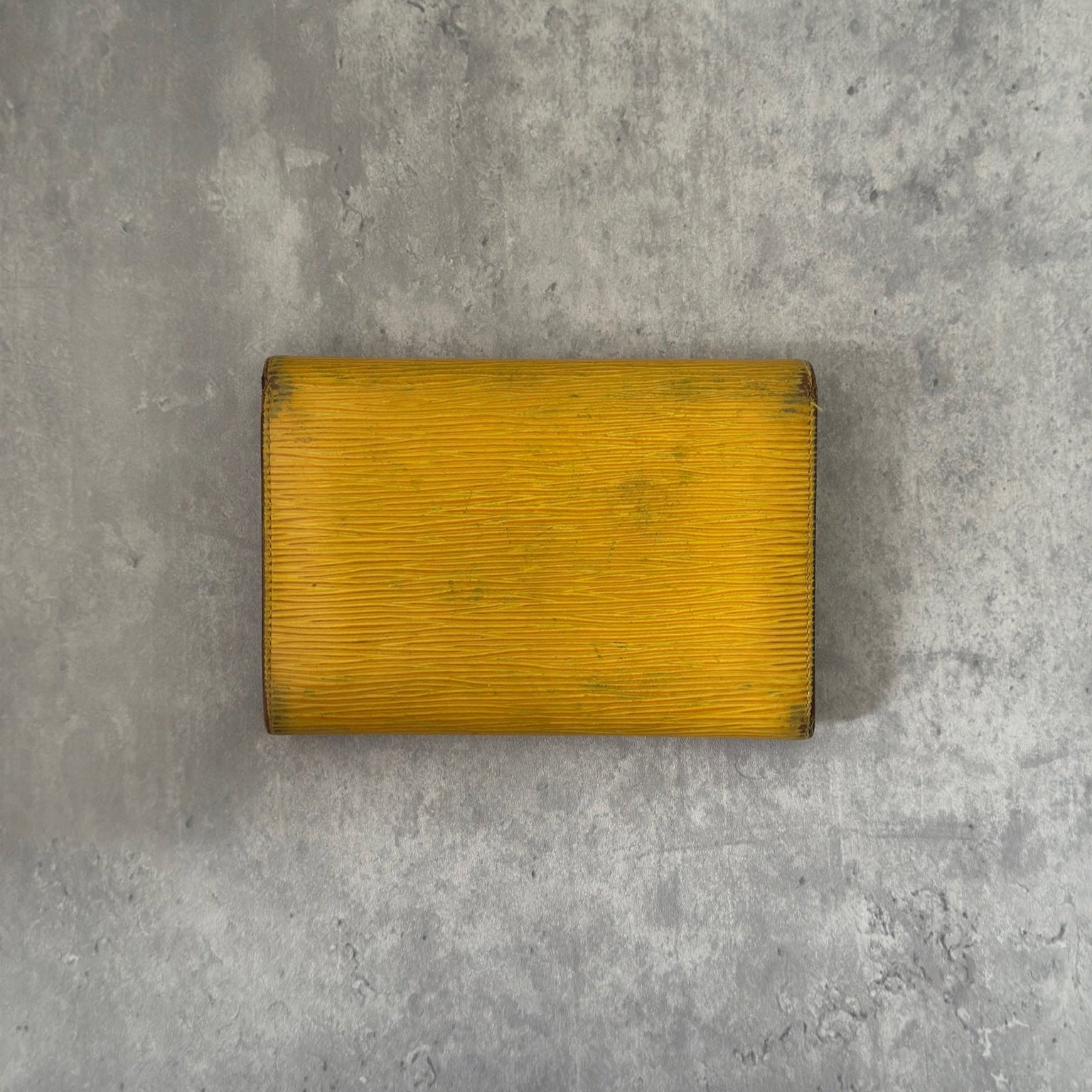 Louis Vuitton Epi leather wallet in yellow with purple leather interior, showcasing multiple card slots and a spacious bill compartment, a blend of functionality and luxury.