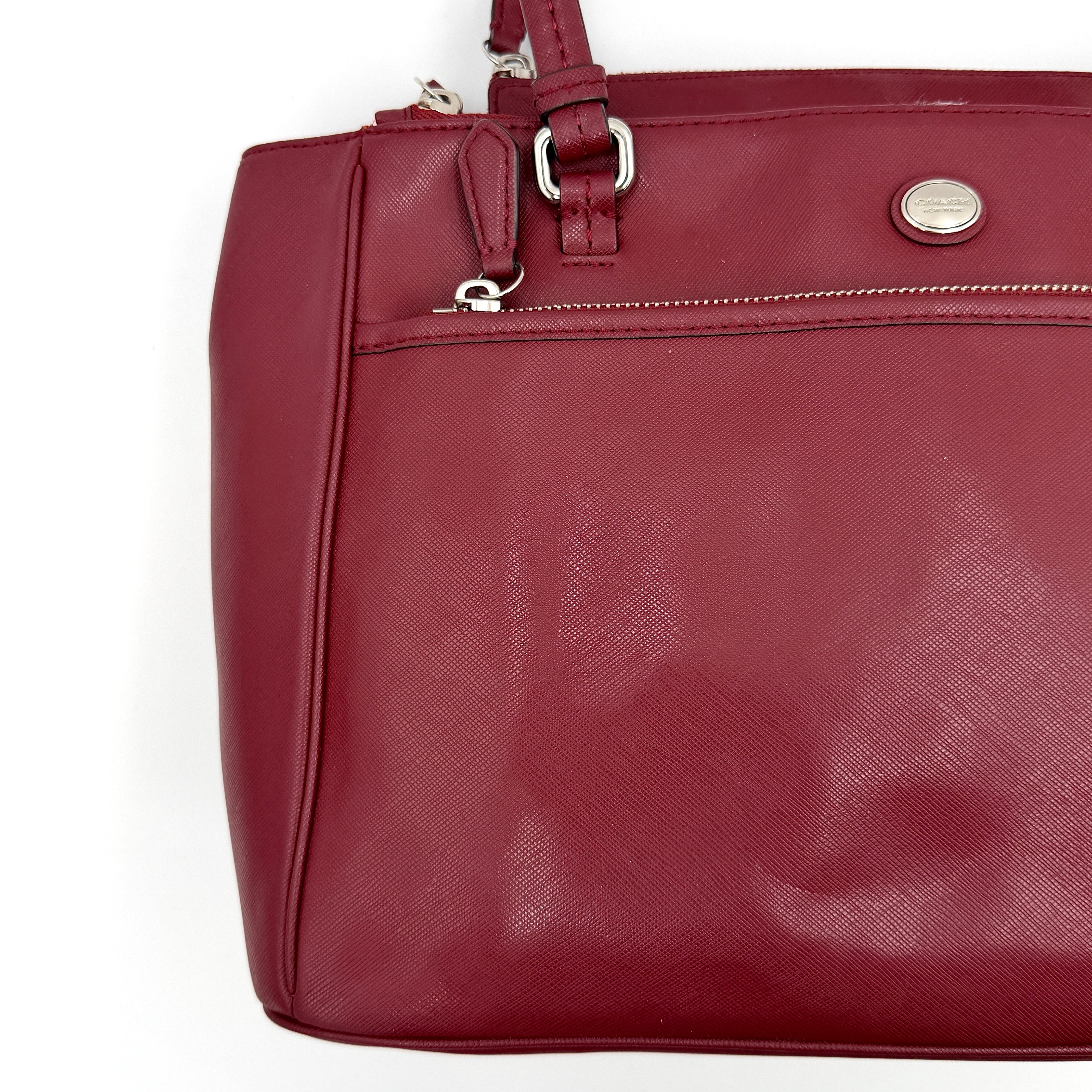 Coach 2Way Peyton Carryall Shoulder Bag in maroon leather with silver hardware, top handles, and detachable strap styled beside the bag.