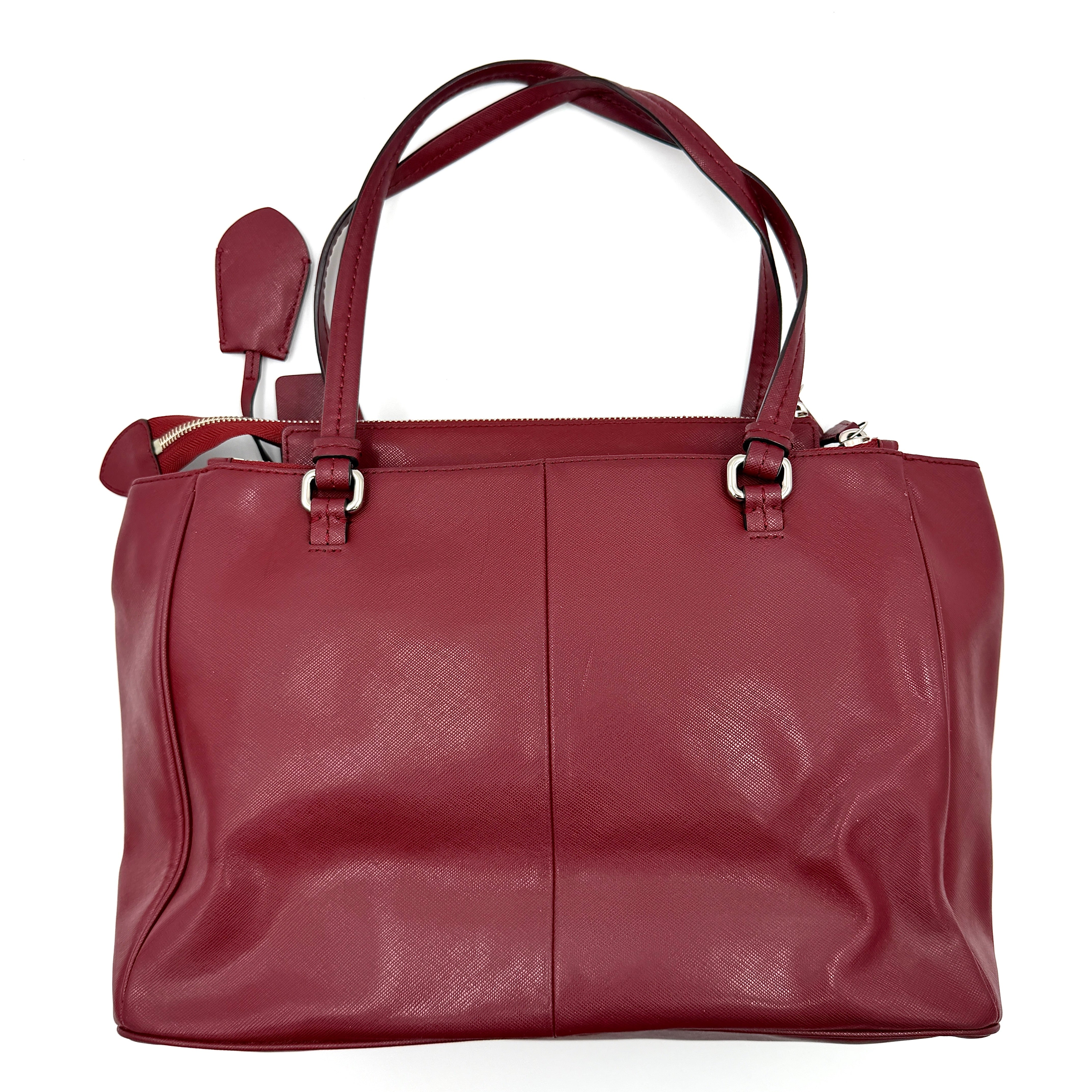 Coach 2Way Peyton Carryall Shoulder Bag in maroon leather with silver hardware, top handles, and detachable strap styled beside the bag.