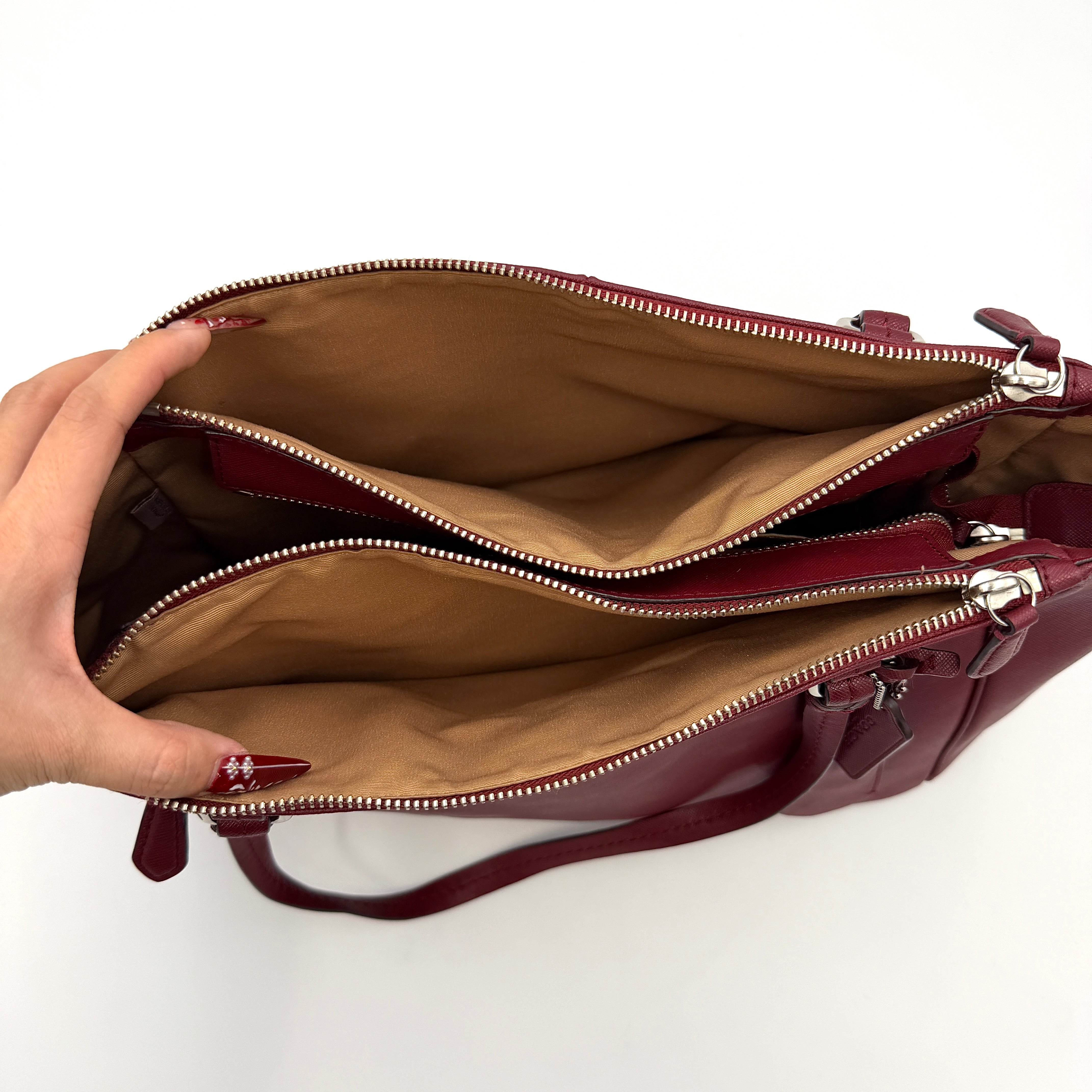 Coach 2Way Peyton Carryall Shoulder Bag in maroon leather with silver hardware, top handles, and detachable strap styled beside the bag.