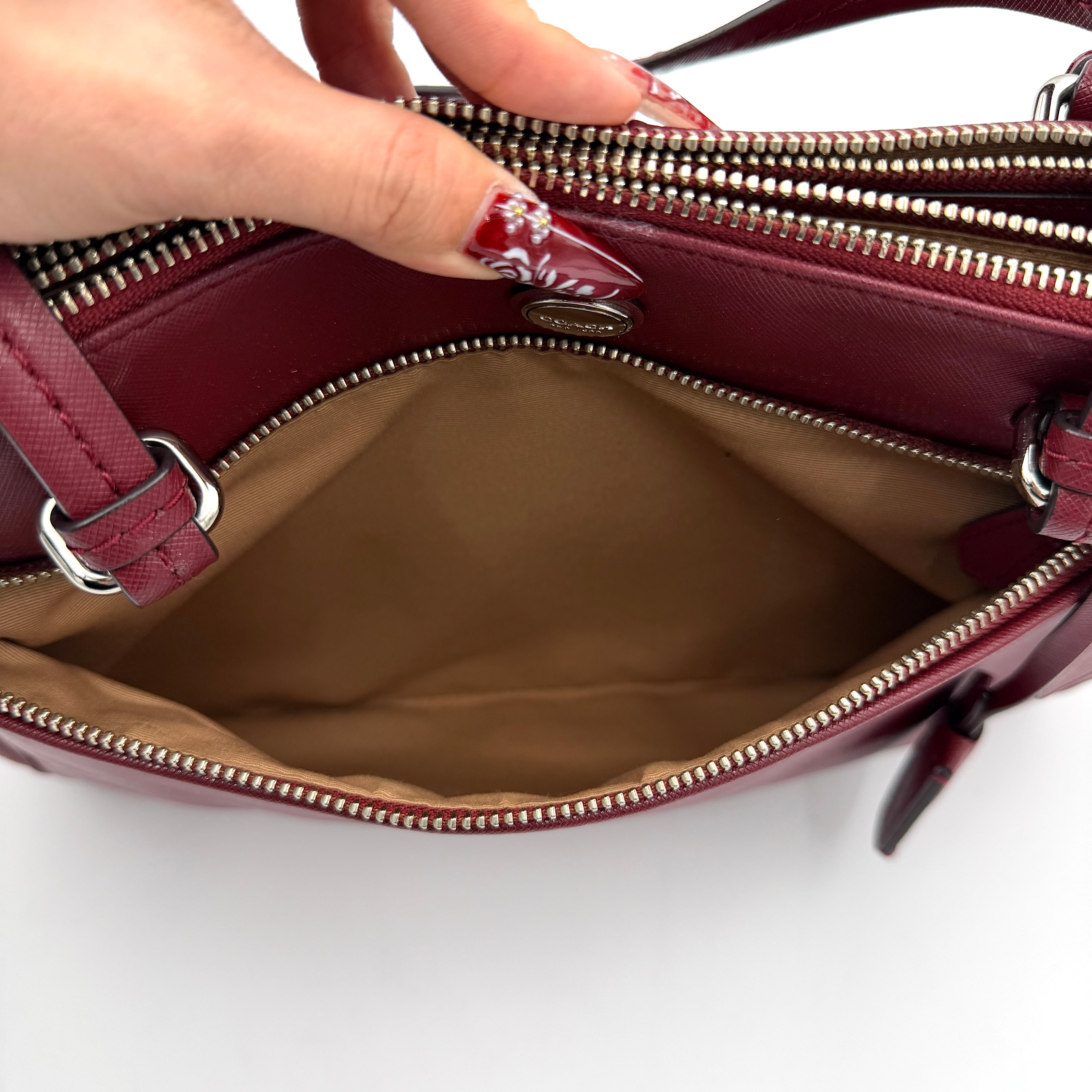 Coach 2Way Peyton Carryall Shoulder Bag in maroon leather with silver hardware, top handles, and detachable strap styled beside the bag.