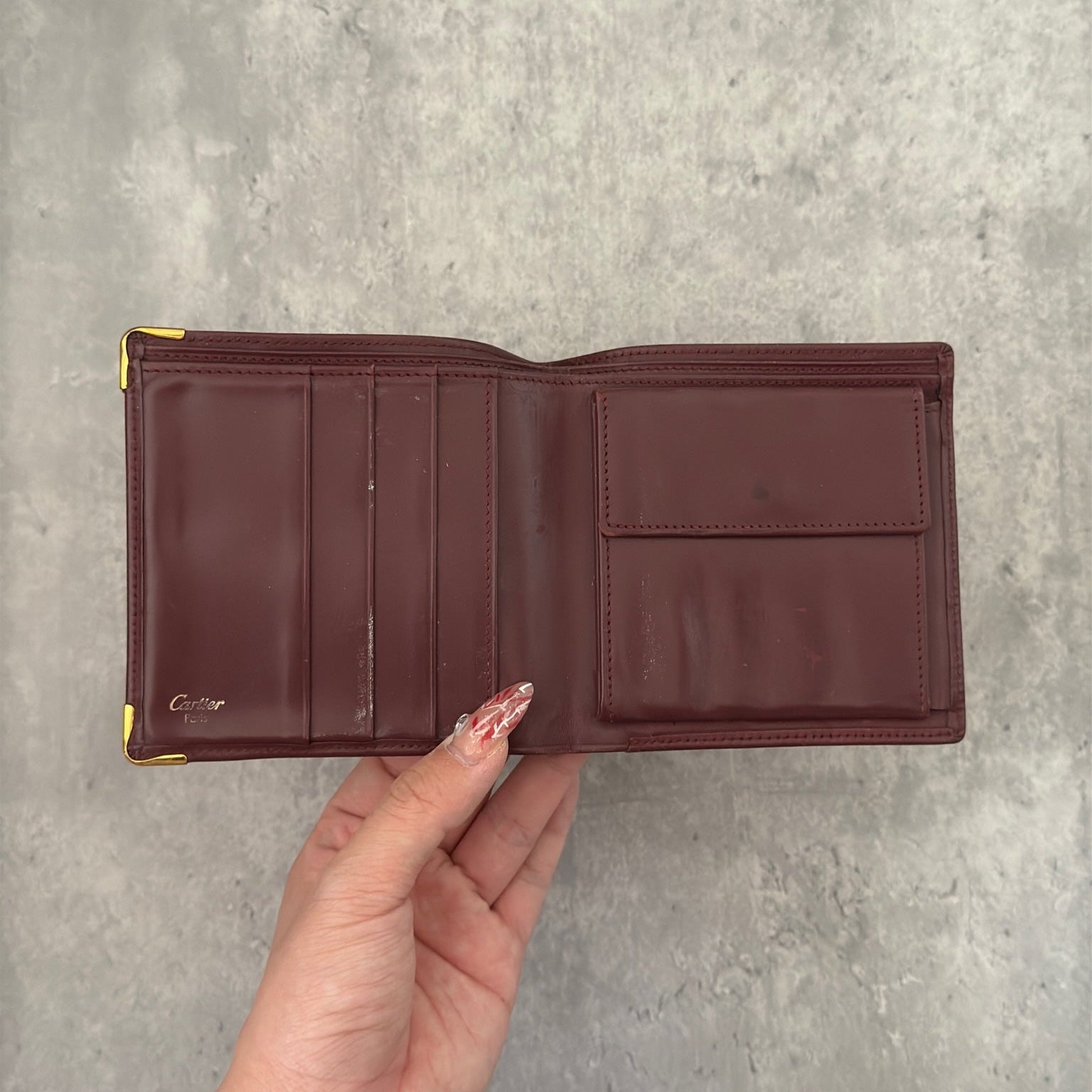 Cartier burgundy patent leather cardholder with multiple card slots, showcasing a luxurious and glossy finish, ideal for elegant organization.