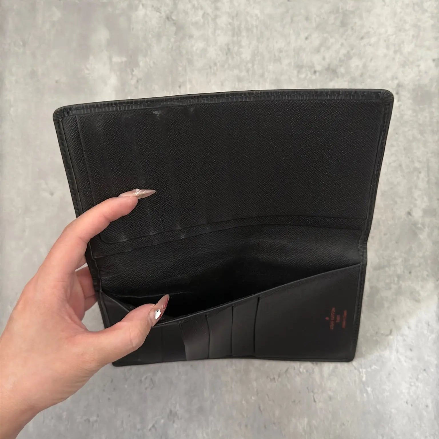 Louis Vuitton Porte Yen Cartes Credit Long Wallet in black Epi leather, featuring multiple card slots, a bill compartment, and LV embossed logo, epitomizing luxury and functionality.