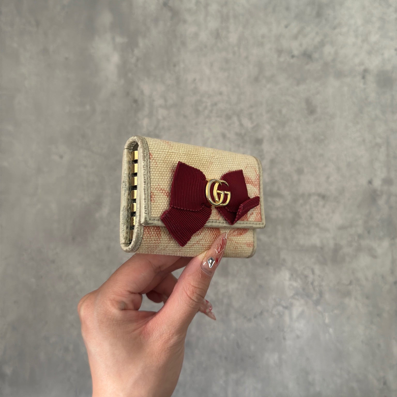 Gucci Herbarium floral pattern key case in beige with red bow, multiple key hooks, and snap closure, available exclusively at Elevated Studios.