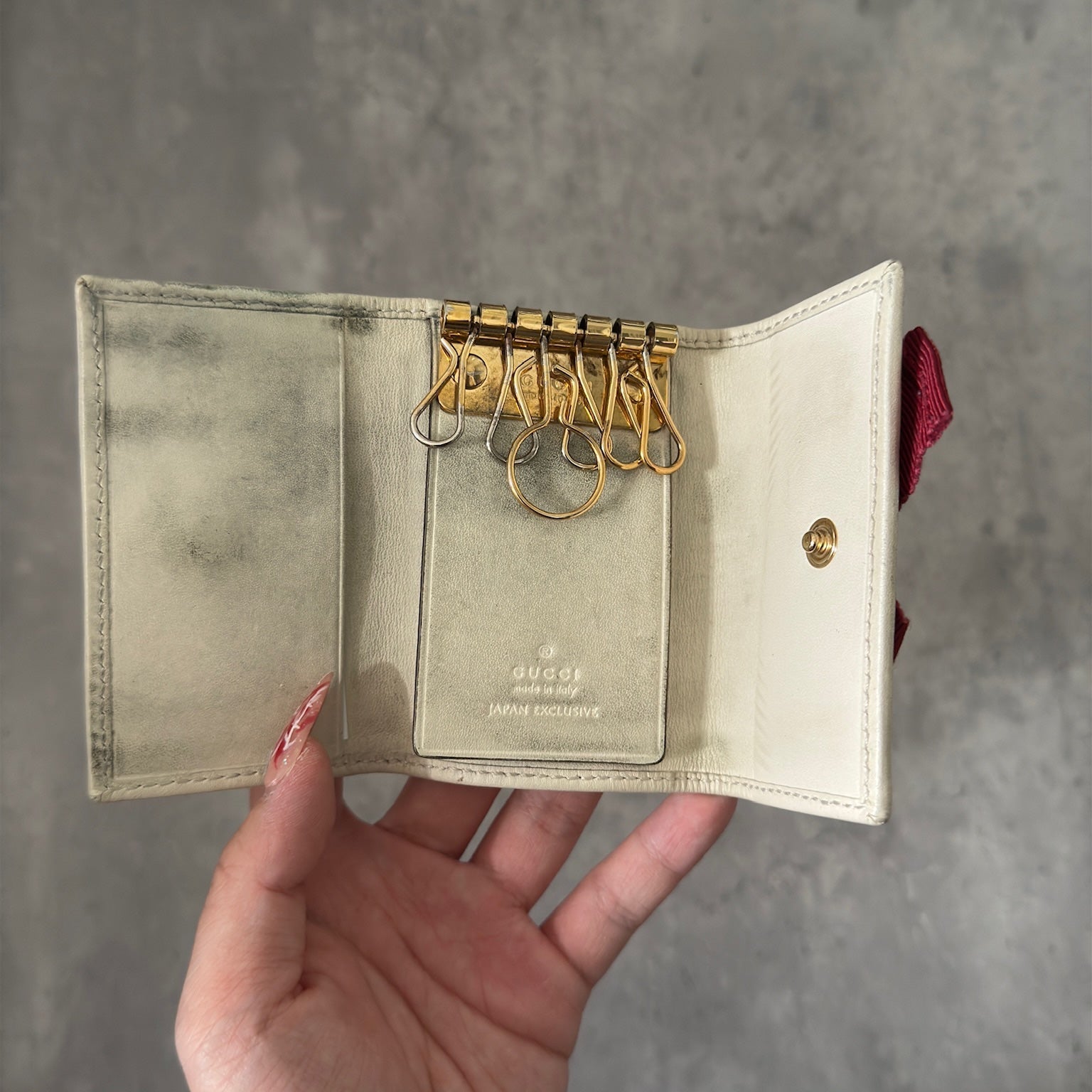 Gucci Herbarium floral pattern key case in beige with red bow, multiple key hooks, and snap closure, available exclusively at Elevated Studios.