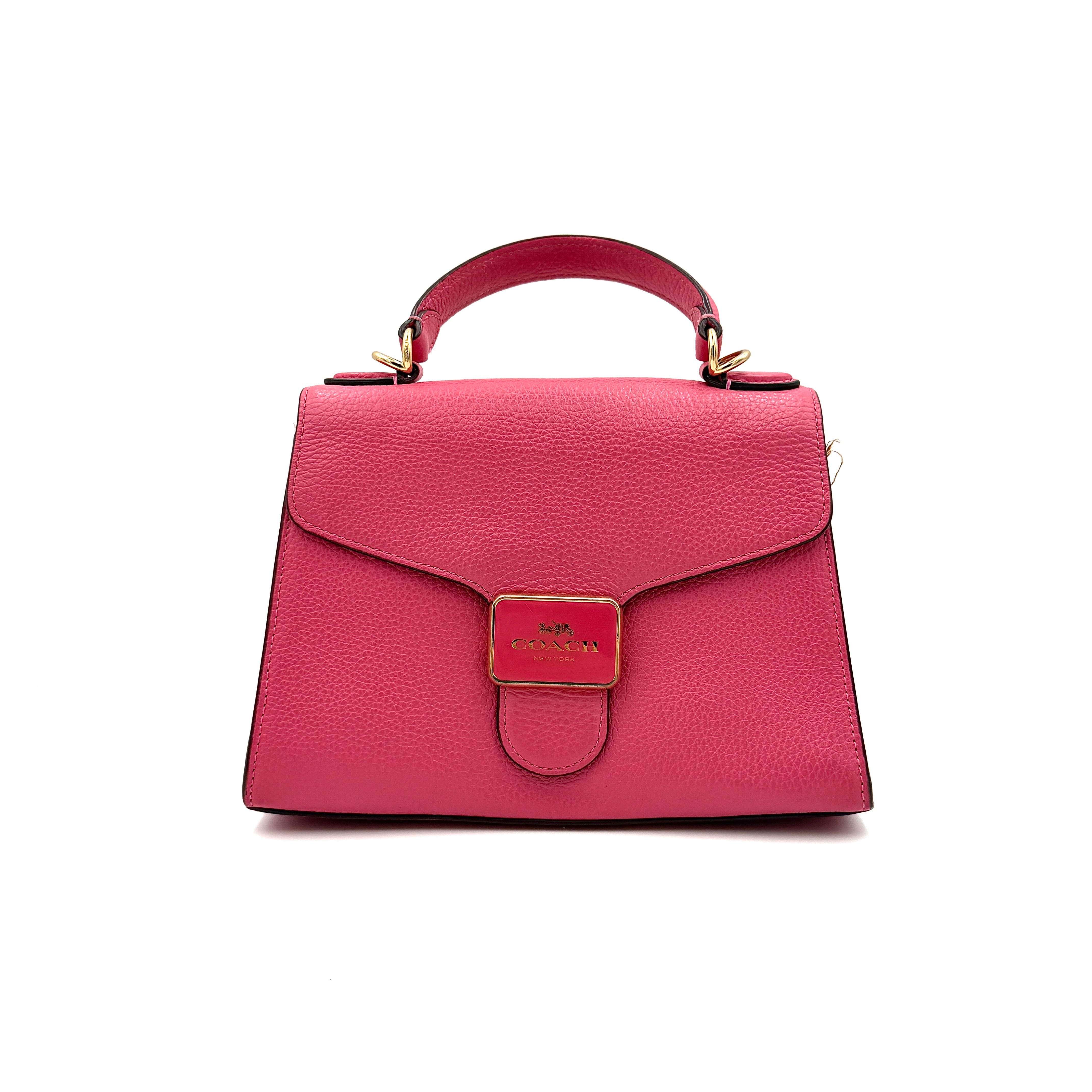 Coach Pepper Satchel in bold pink pebbled leather, featuring a structured silhouette and gold logo push-lock hardware.