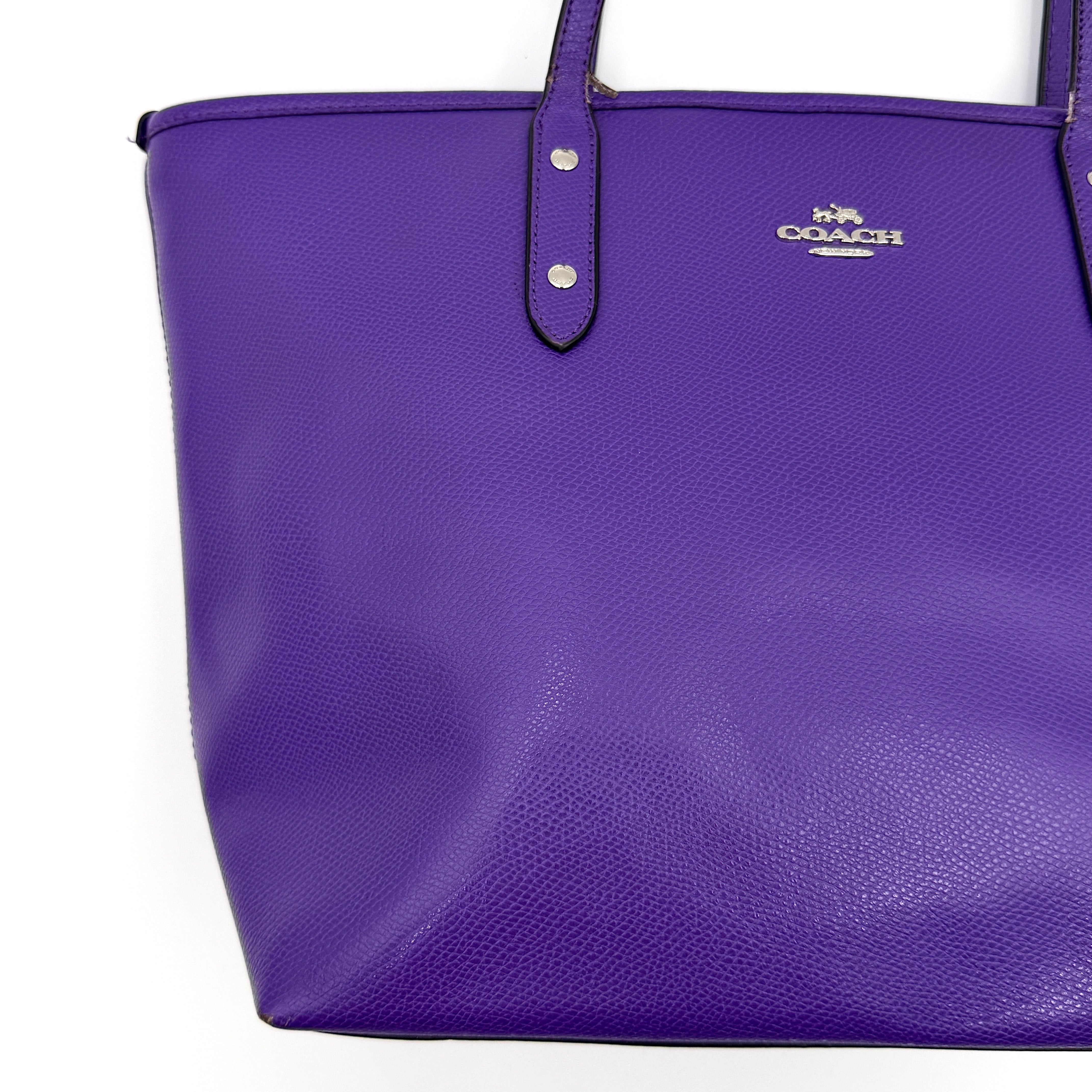 Coach City Zip Tote Bag in vibrant purple grained leather with dual shoulder straps and silver-tone hardware.
