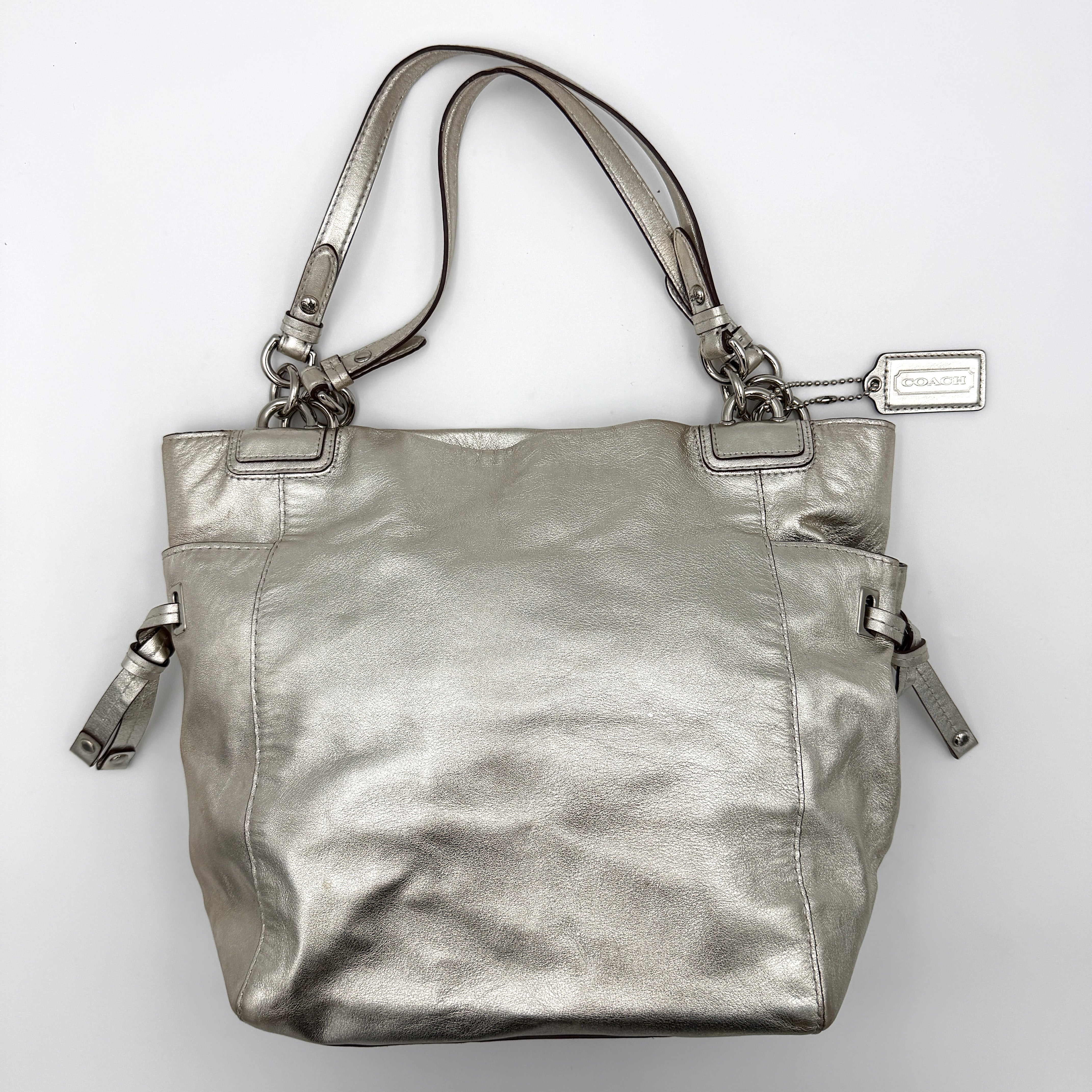 Coach Peyton Metallic Shoulder Bag in shimmering silver leather with dual top handles and polished hardware.