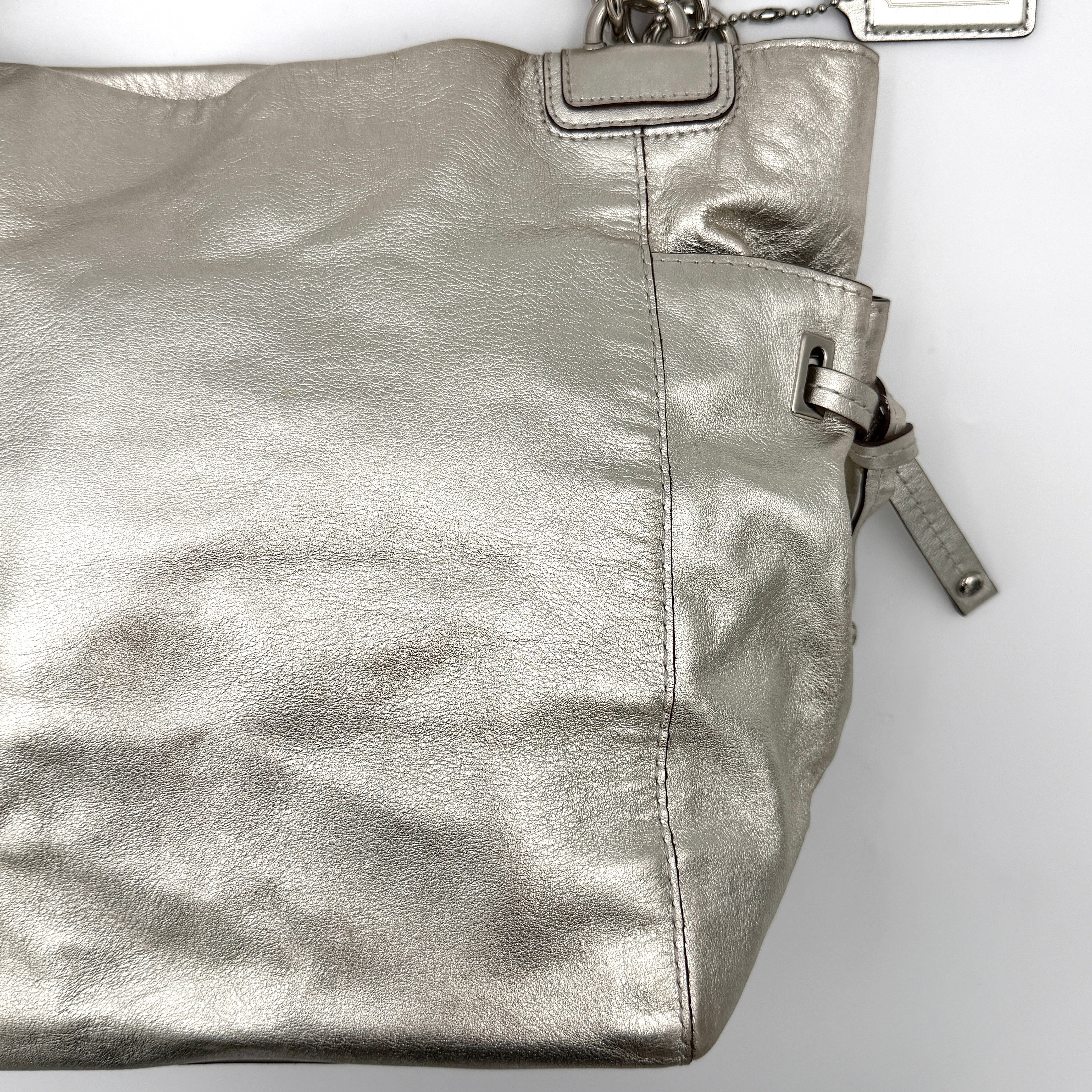 Coach Peyton Metallic Shoulder Bag in shimmering silver leather with dual top handles and polished hardware.