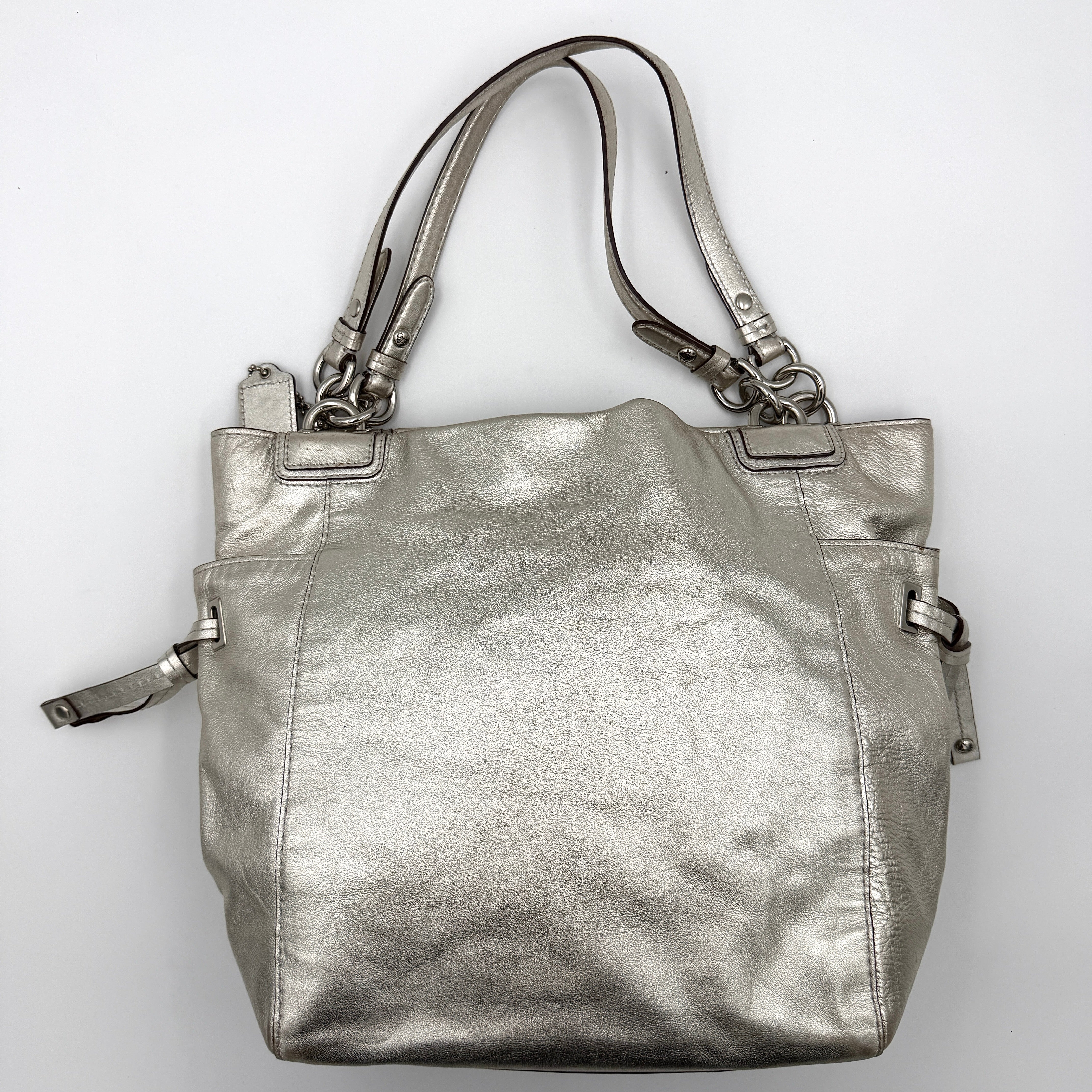 Coach Peyton Metallic Shoulder Bag in shimmering silver leather with dual top handles and polished hardware.