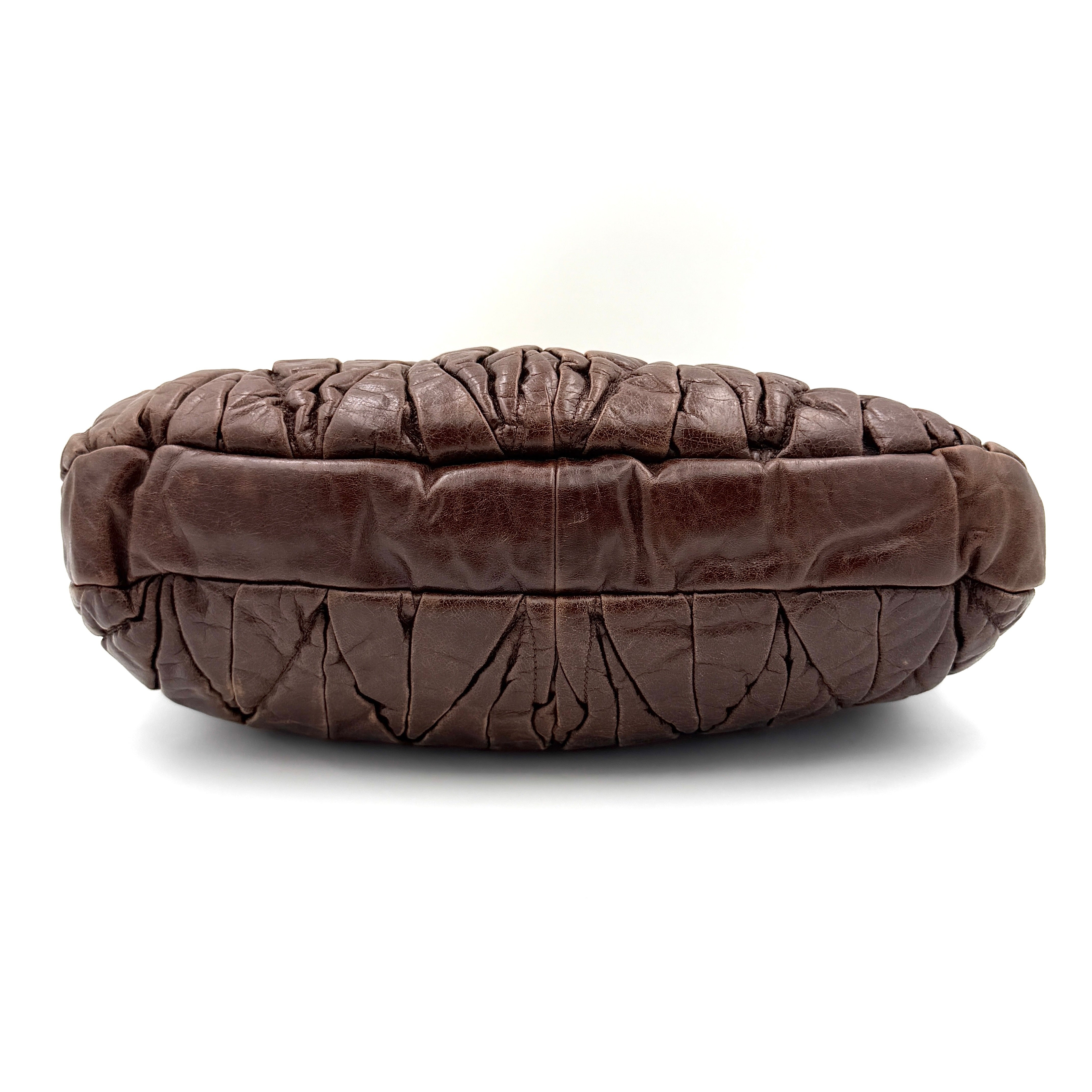 Miu Miu Coffer Hobo bag in deep brown matelassé leather with braided handle, gold hardware, and detachable strap.