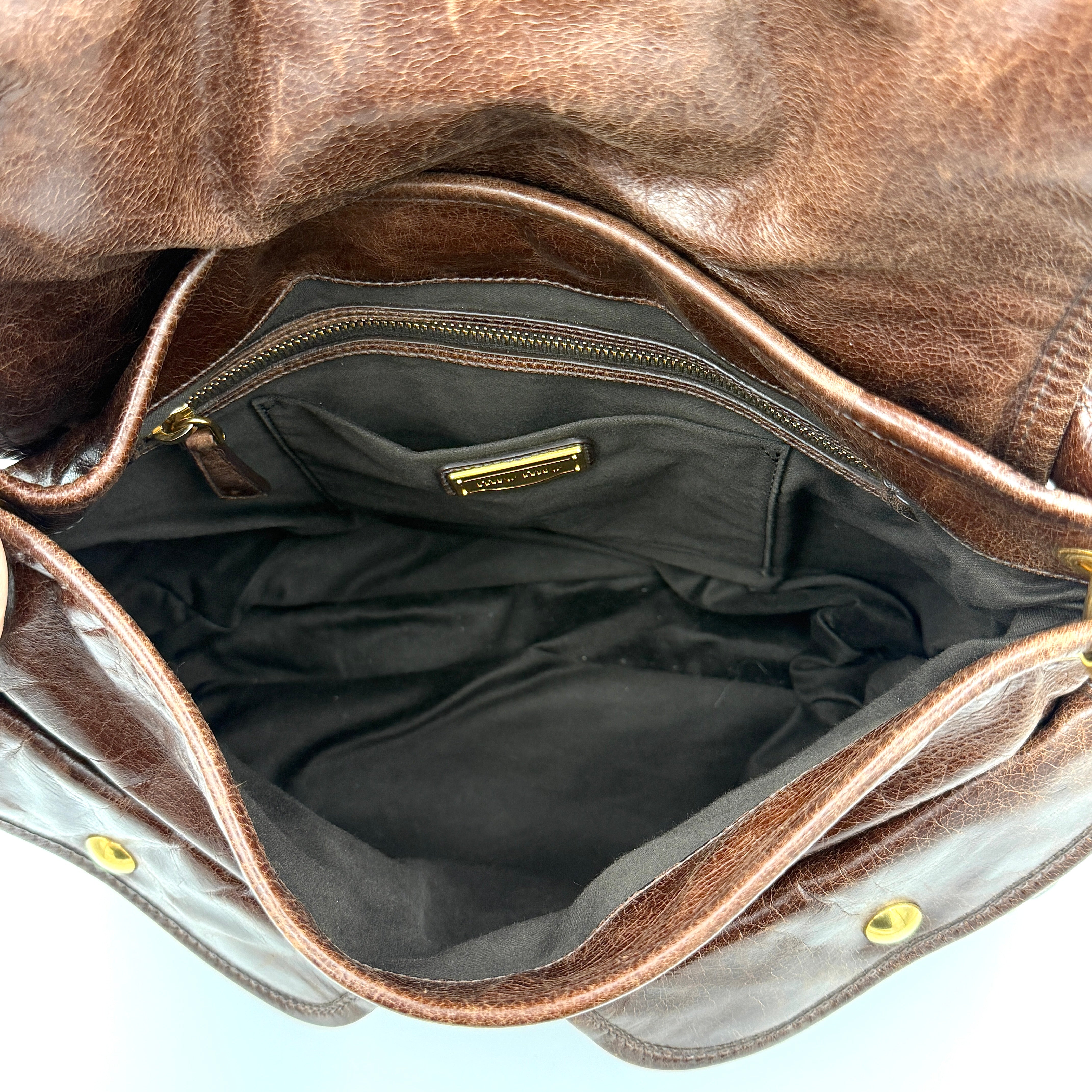 Miu Miu Coffer Hobo bag in deep brown matelassé leather with braided handle, gold hardware, and detachable strap.
