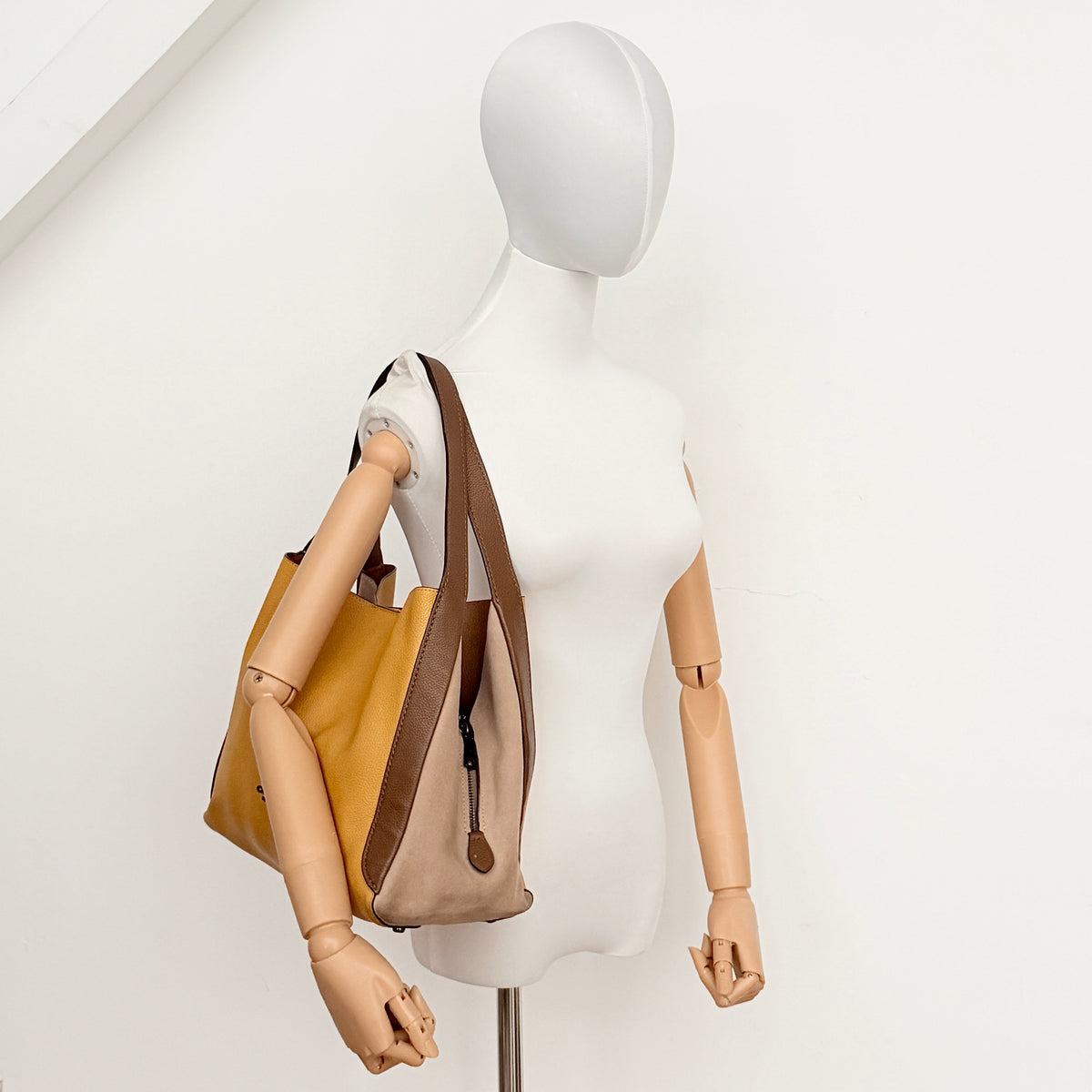 Coach Hadley Colorblock Hobo bag in yellow and brown leather with double top handles and suede side panels, shown against a white background.