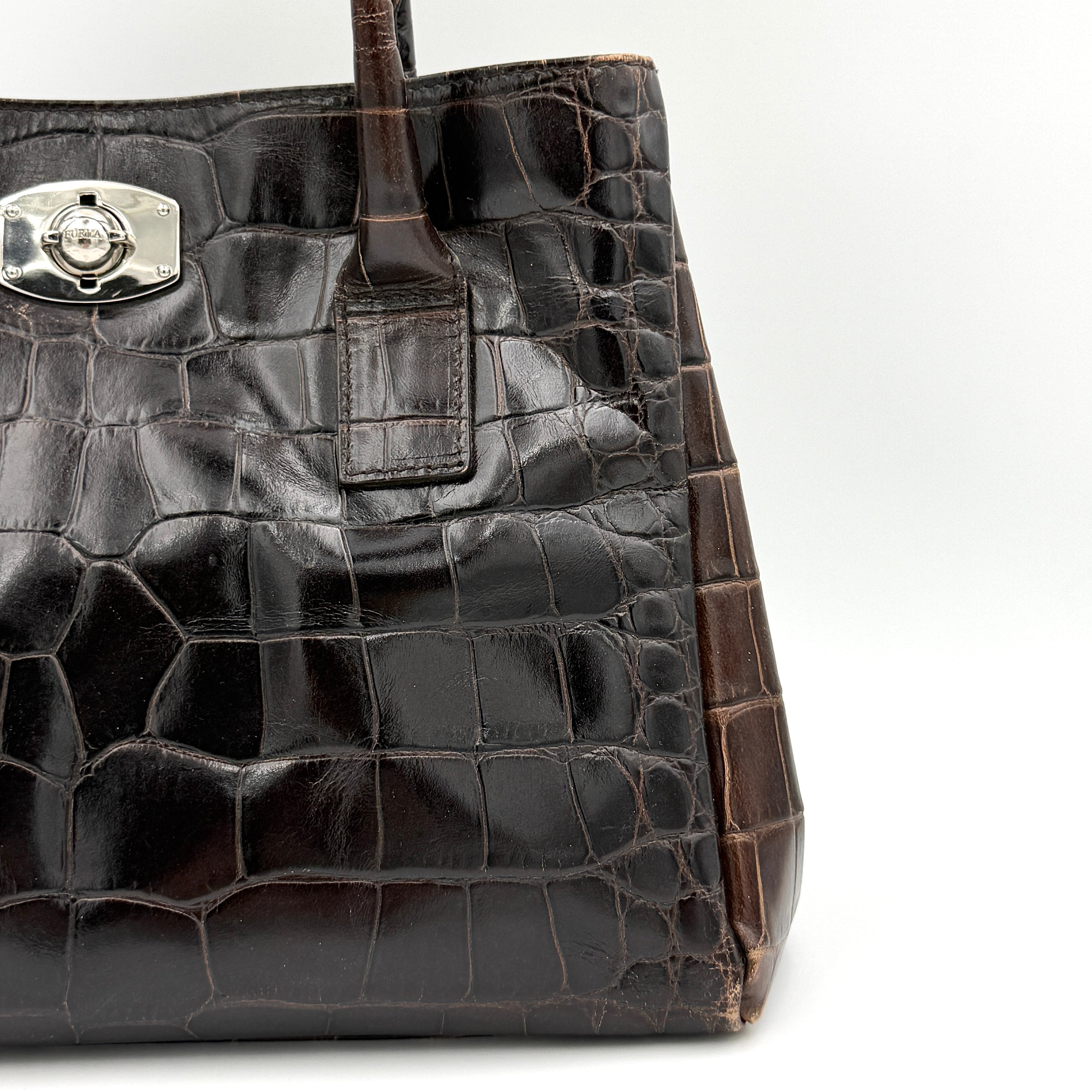 Furla croc-embossed dark brown leather handbag with structured silhouette, dual top handles, and silver turn-lock closure.