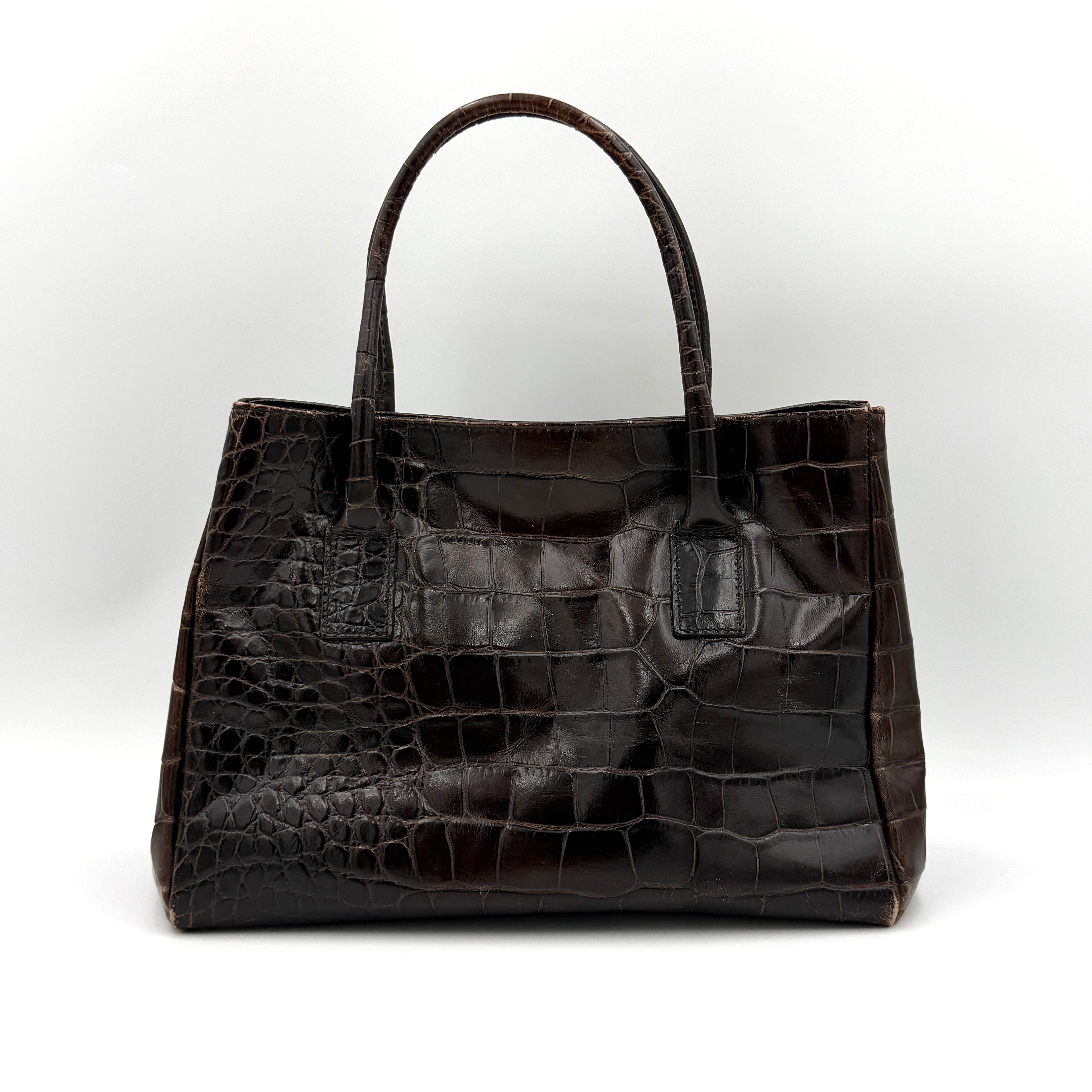 Furla croc-embossed dark brown leather handbag with structured silhouette, dual top handles, and silver turn-lock closure.