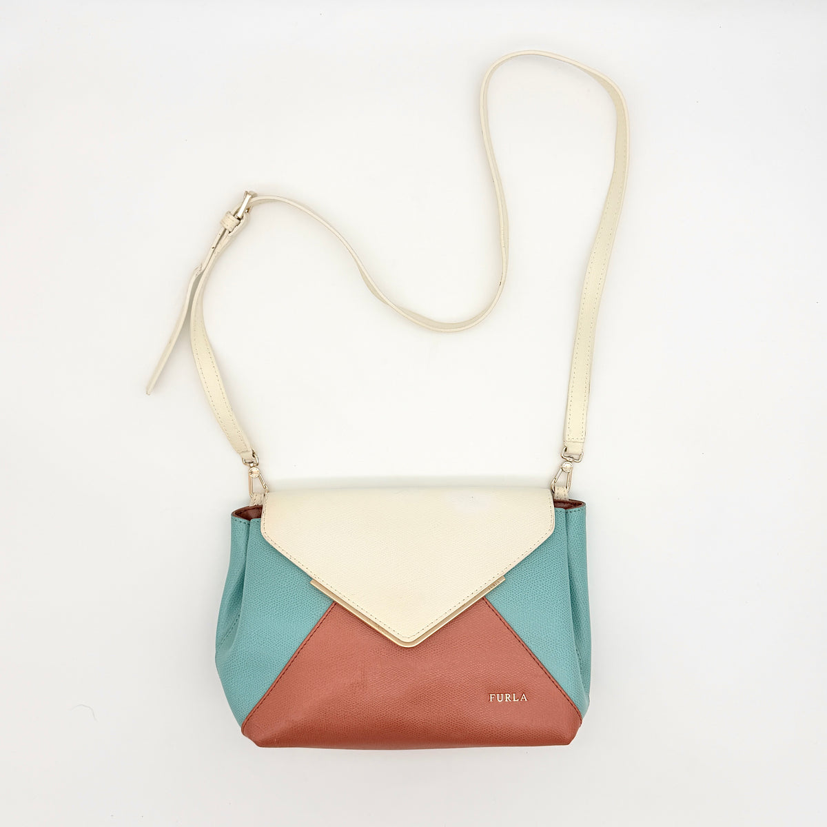 Furla Kelis crossbody bag in brown, blue, and cream leather with envelope flap and gold-tone hardware, displayed on a Furla dust bag.