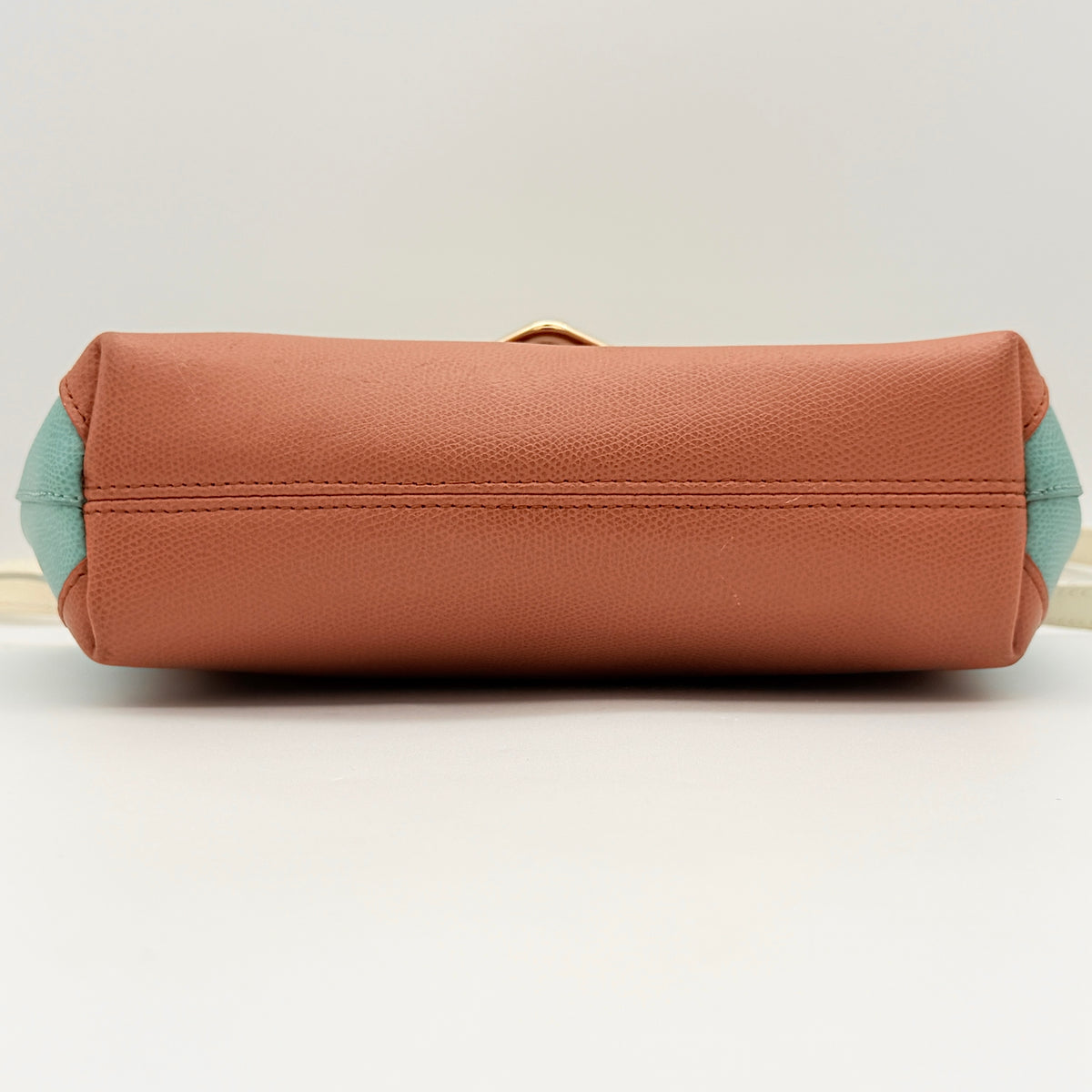 Furla Kelis crossbody bag in brown, blue, and cream leather with envelope flap and gold-tone hardware, displayed on a Furla dust bag.