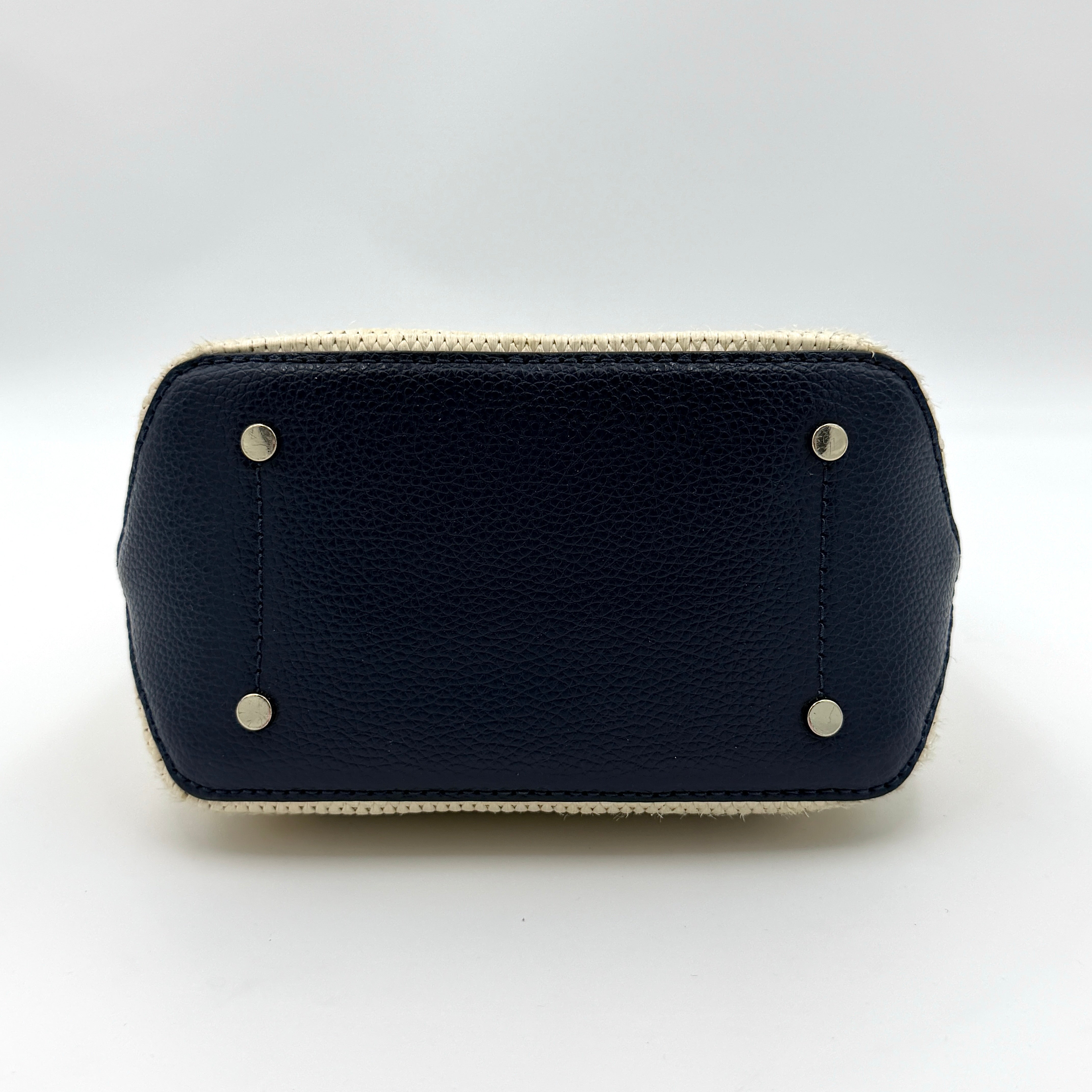 Front view of the Kate Spade Eva Straw Bucket Bag in cream, with navy leather trim and silver-tone hardware.
