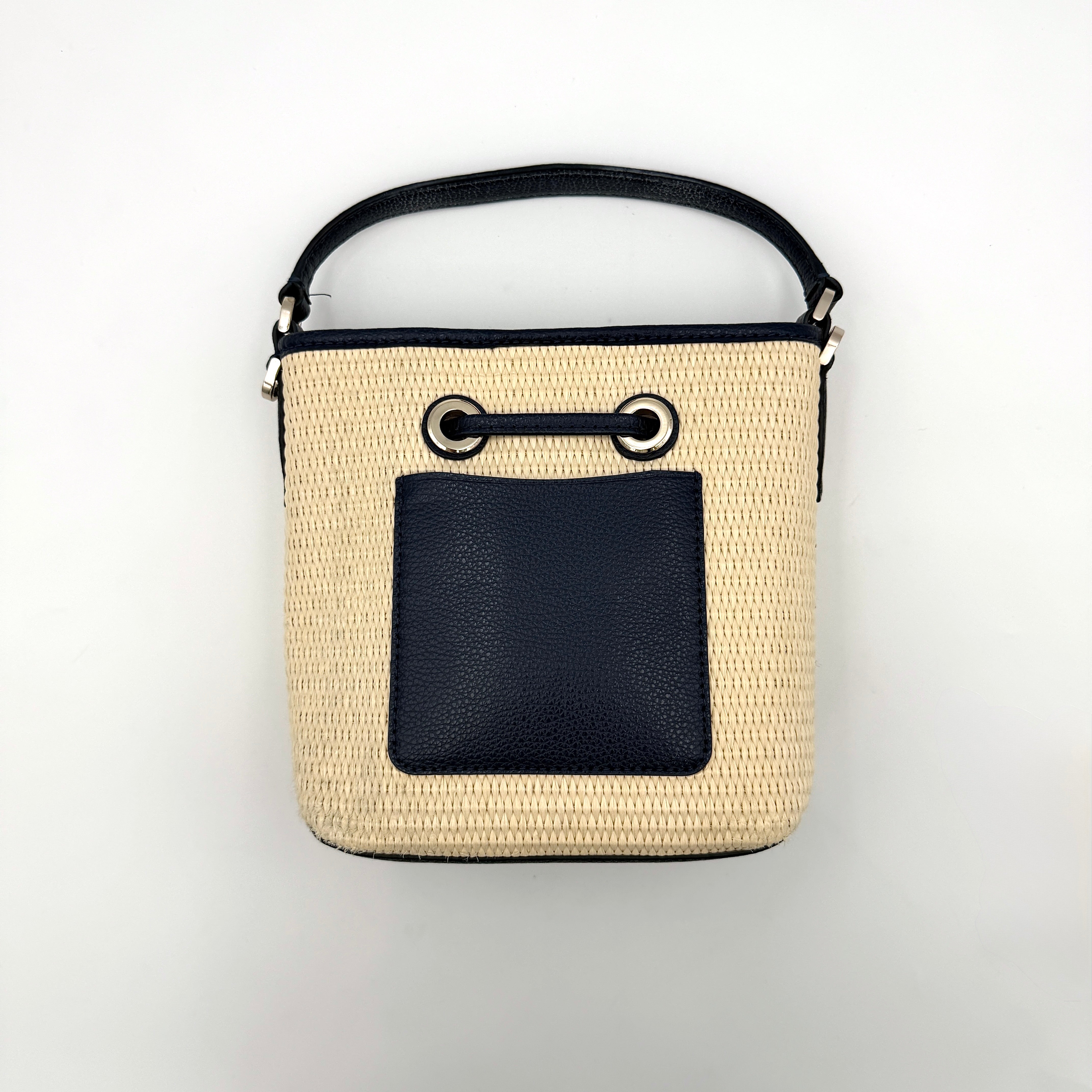 Front view of the Kate Spade Eva Straw Bucket Bag in cream, with navy leather trim and silver-tone hardware.