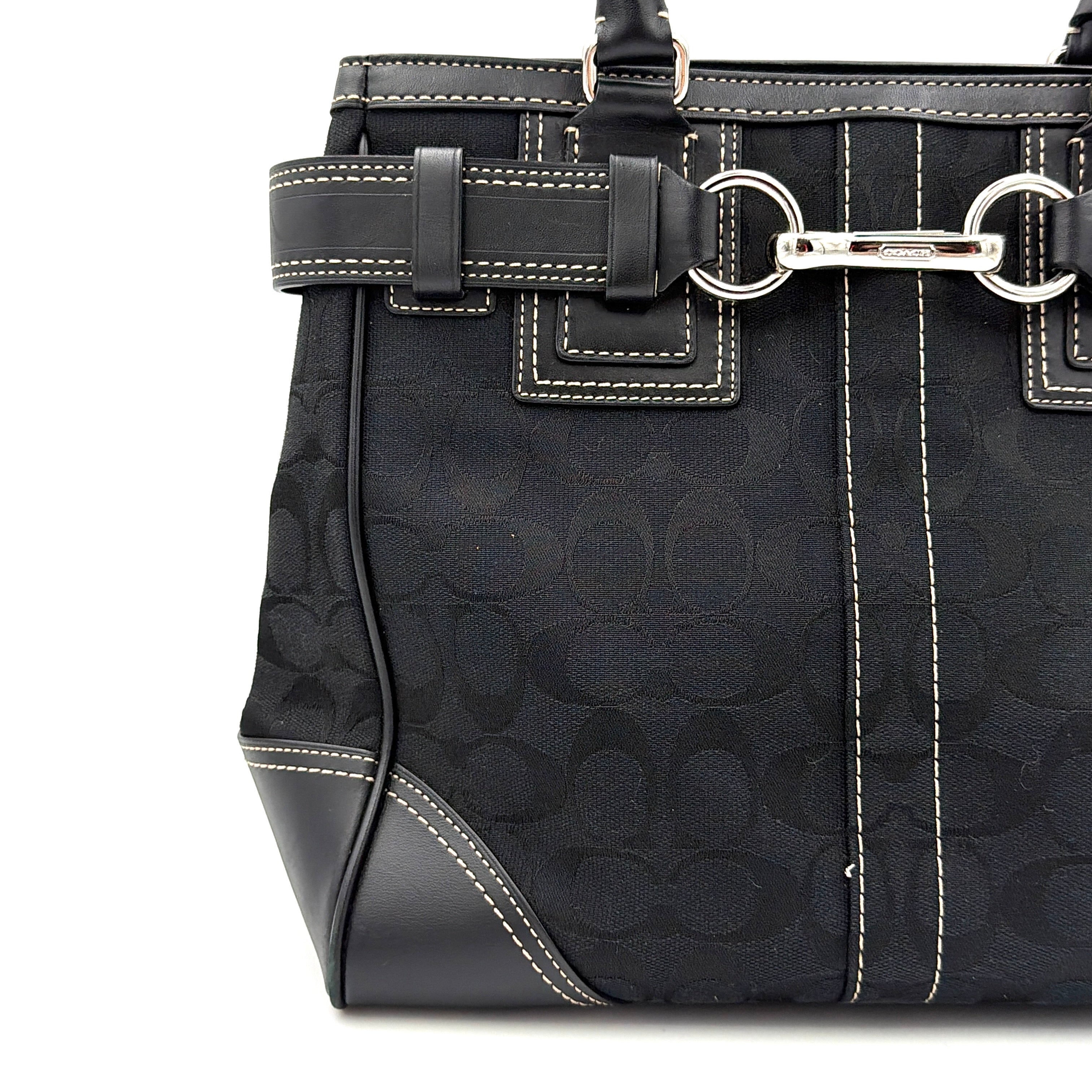 Coach Signature Hampton Carryall in black with monogram jacquard, belted leather trim, and silver-tone horsebit hardware.