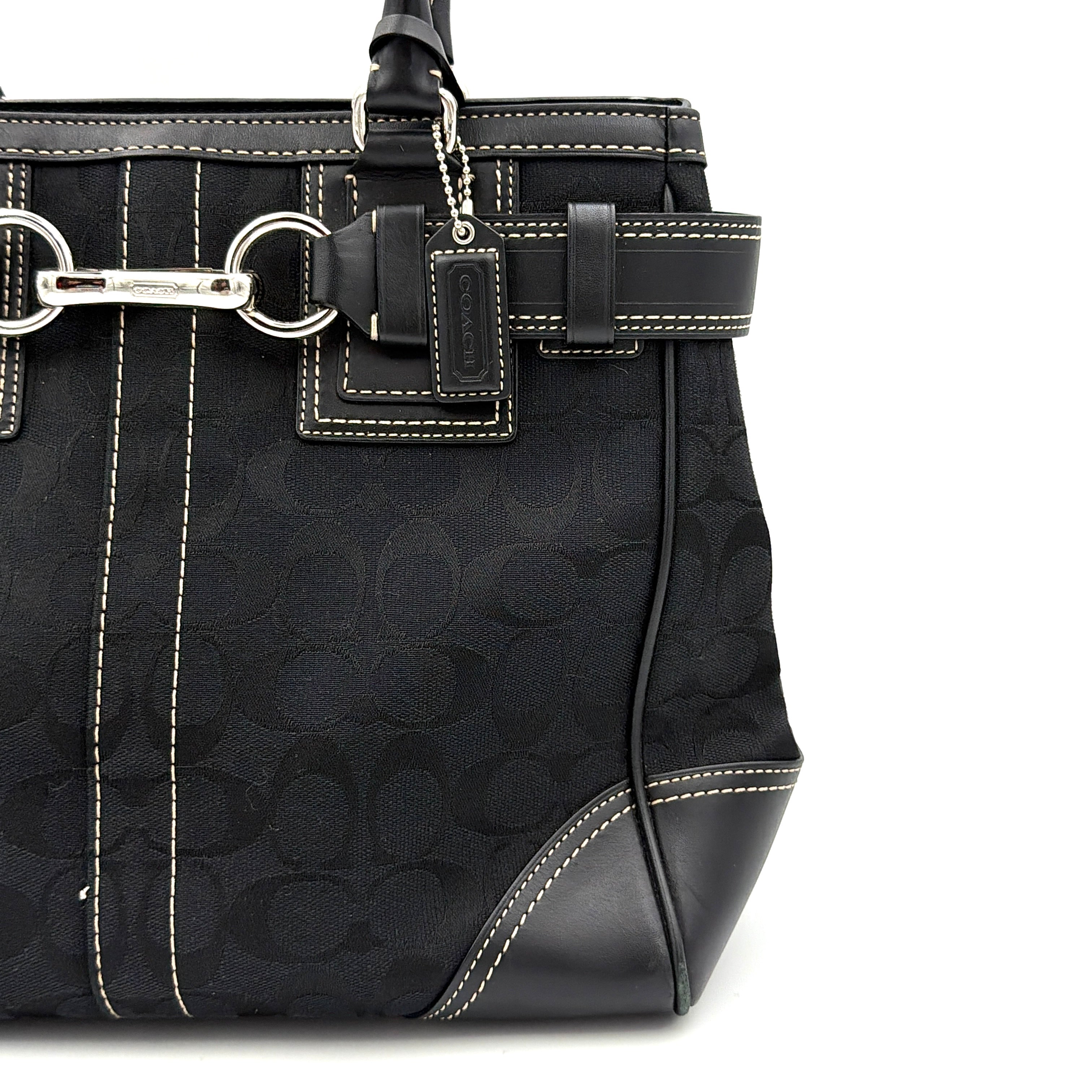 Coach Signature Hampton Carryall in black with monogram jacquard, belted leather trim, and silver-tone horsebit hardware.