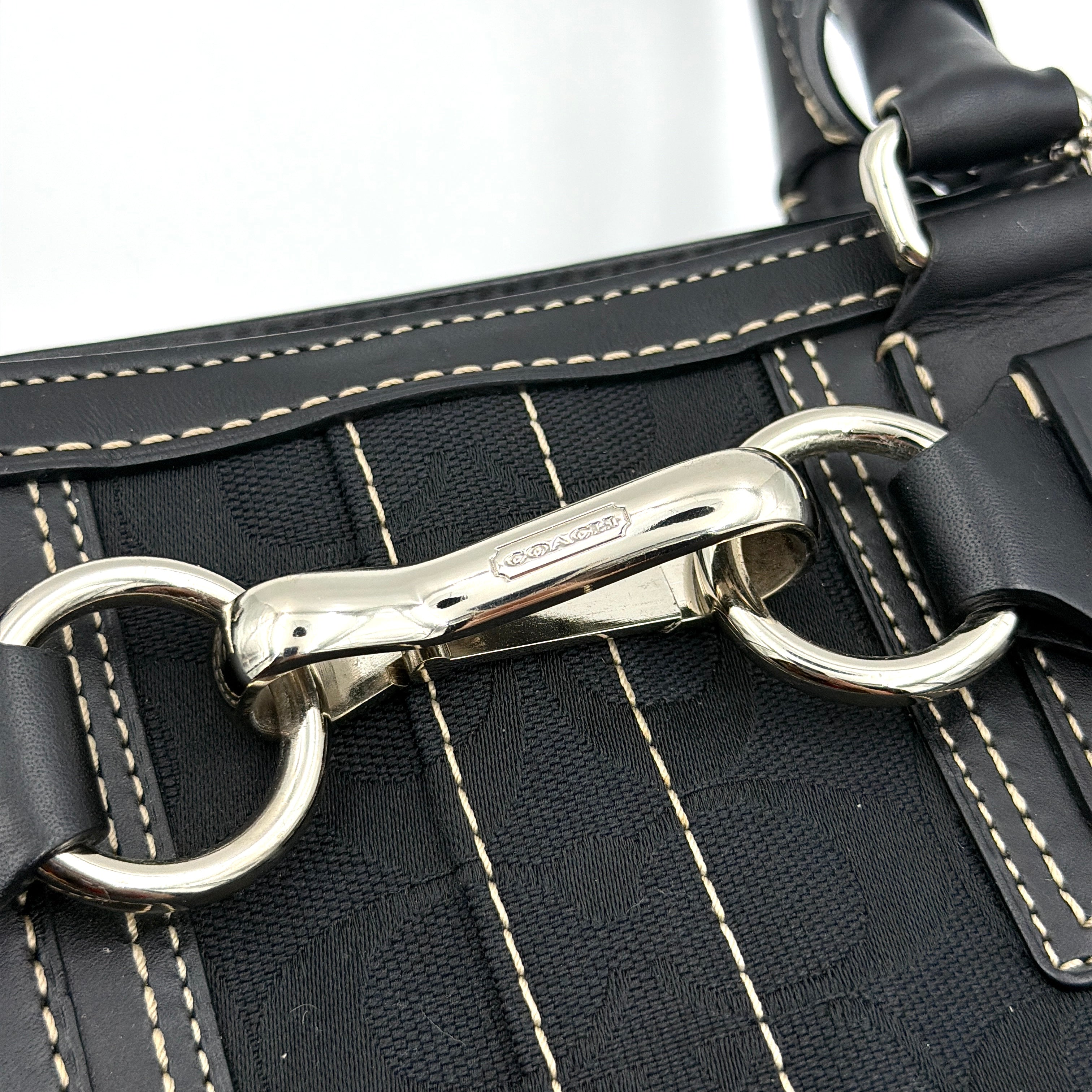 Coach Signature Hampton Carryall in black with monogram jacquard, belted leather trim, and silver-tone horsebit hardware.