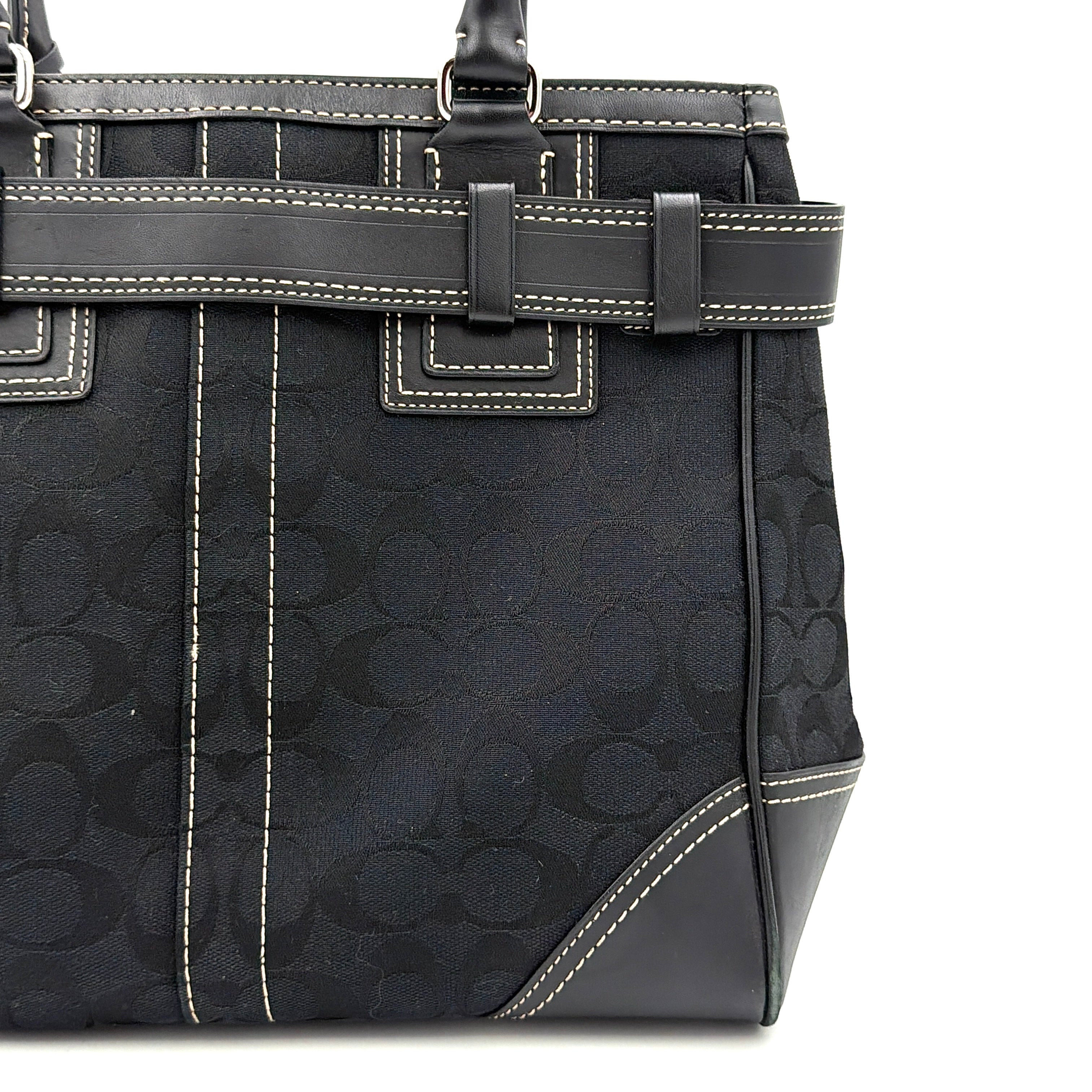 Coach Signature Hampton Carryall in black with monogram jacquard, belted leather trim, and silver-tone horsebit hardware.
