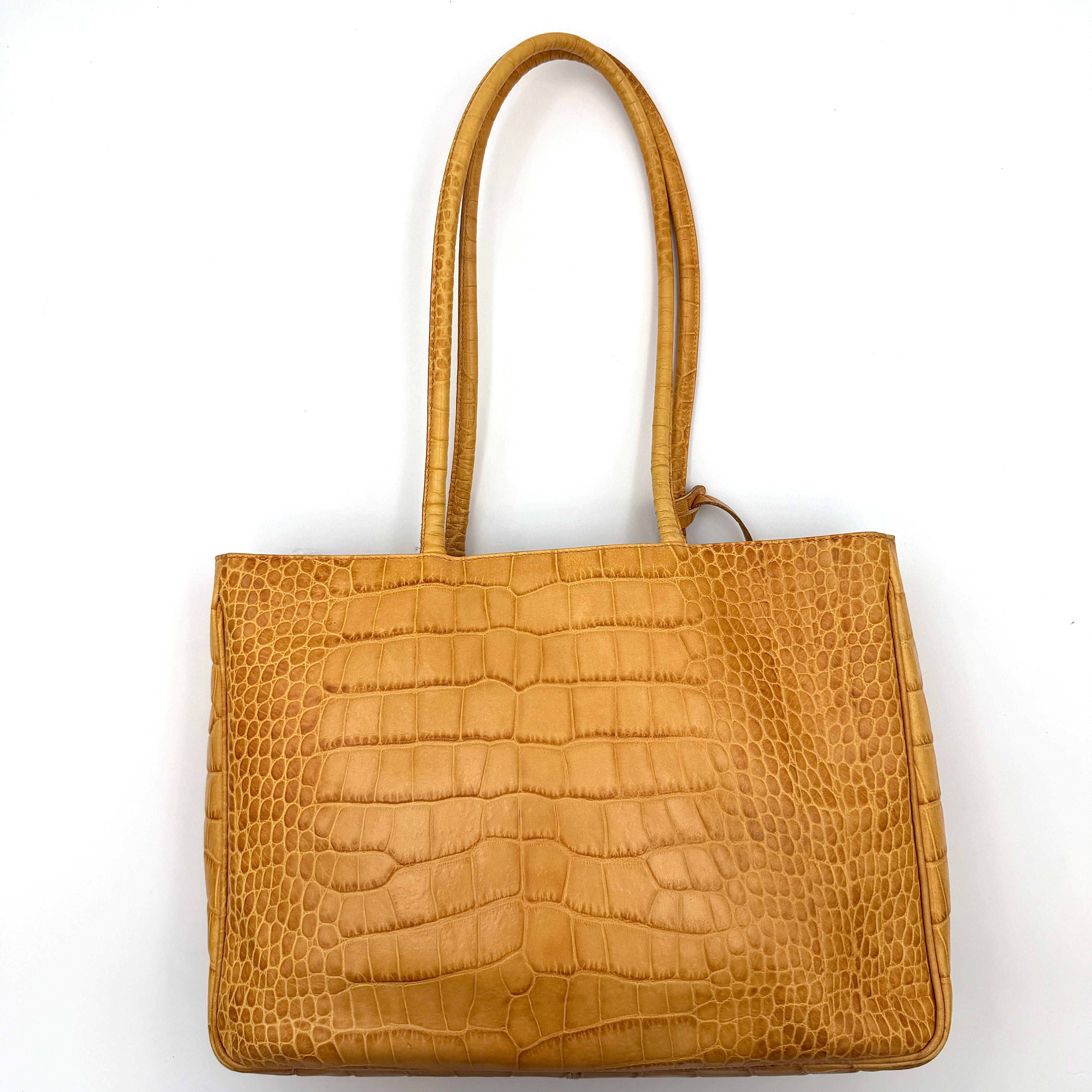 Furla yellow croc-embossed leather tote bag with double handles and matte gold logo charm, presented against a white background.