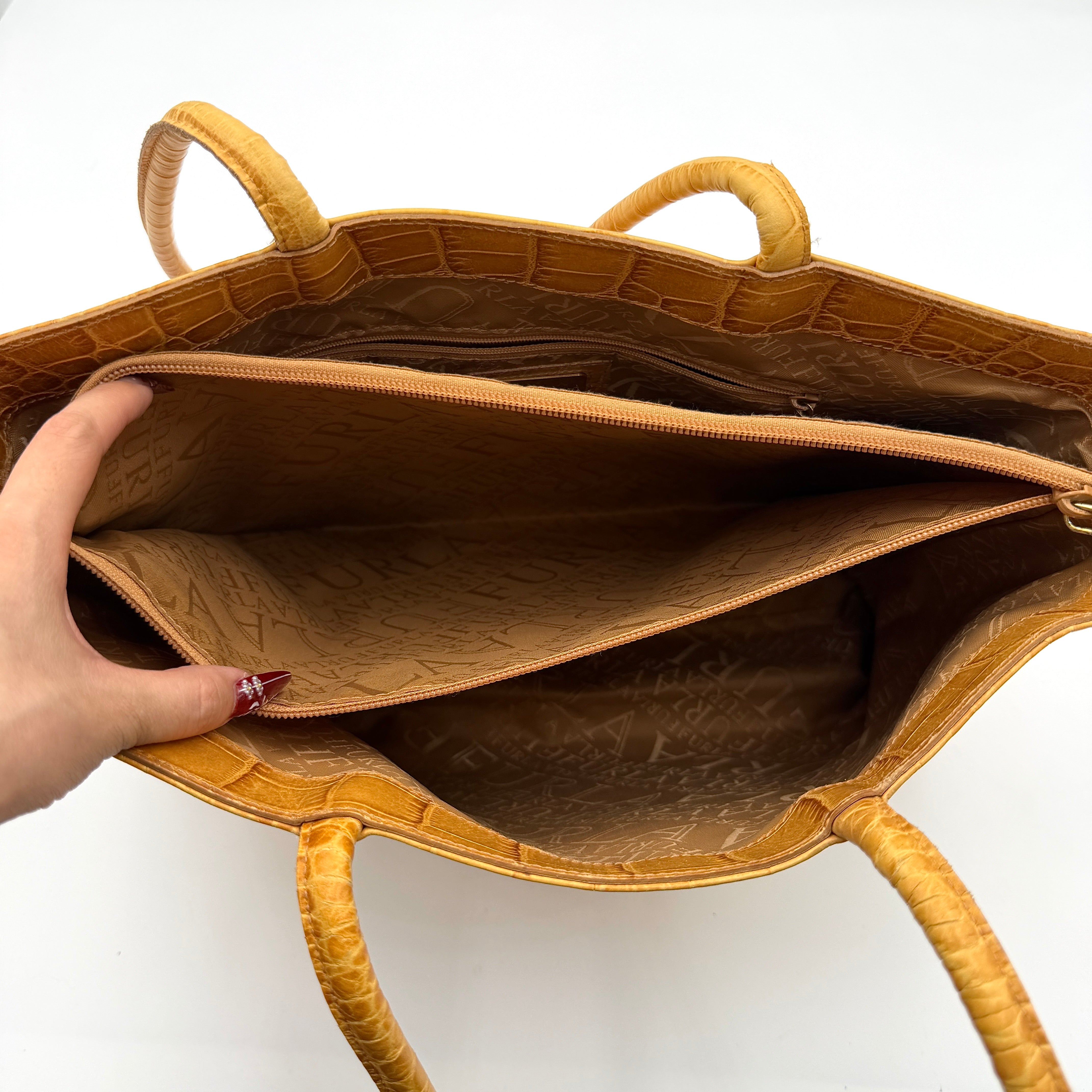 Furla yellow croc-embossed leather tote bag with double handles and matte gold logo charm, presented against a white background.