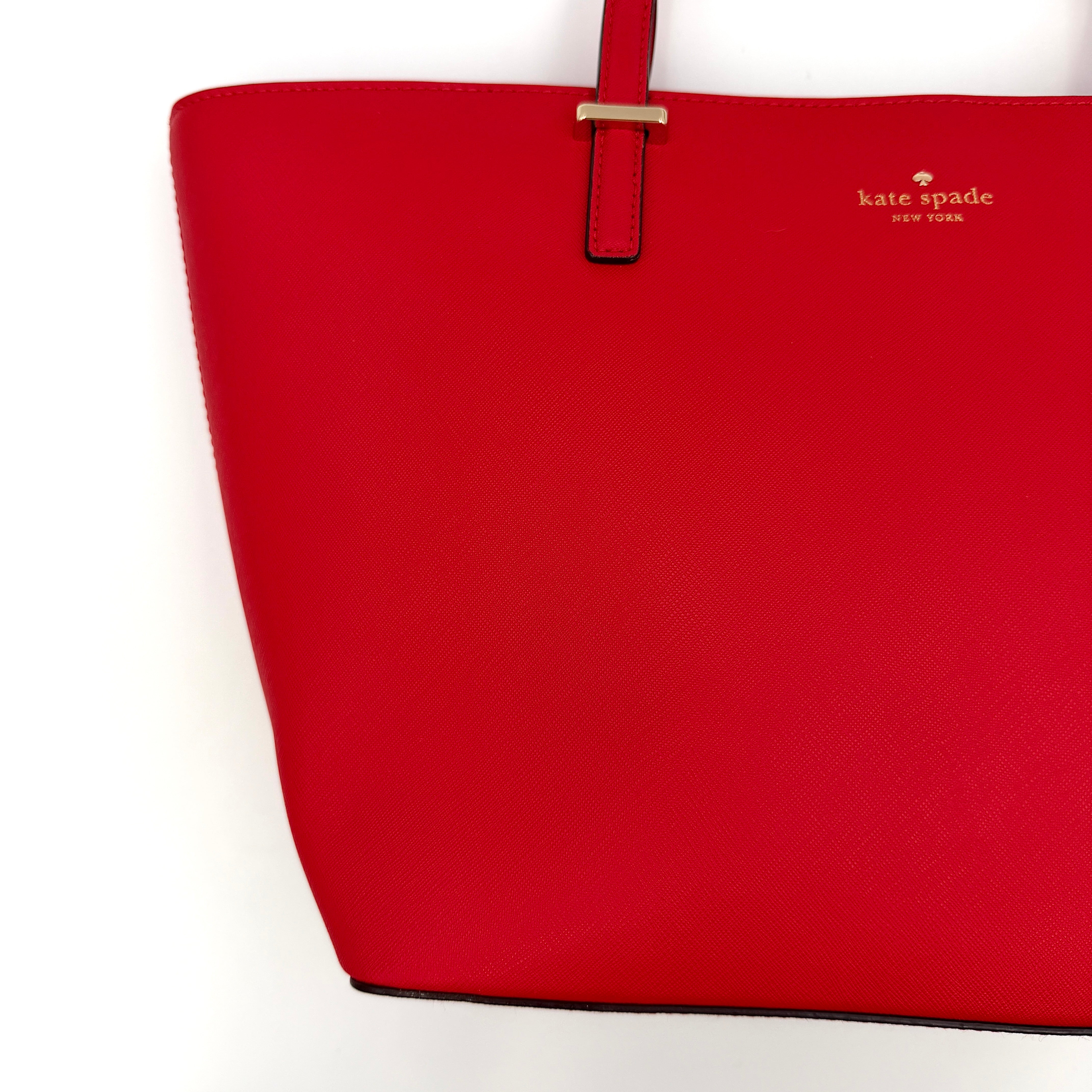 Kate Spade Cedar Street Harmony Tote bag in bold red saffiano leather, featuring dual top handles and gold-tone details.