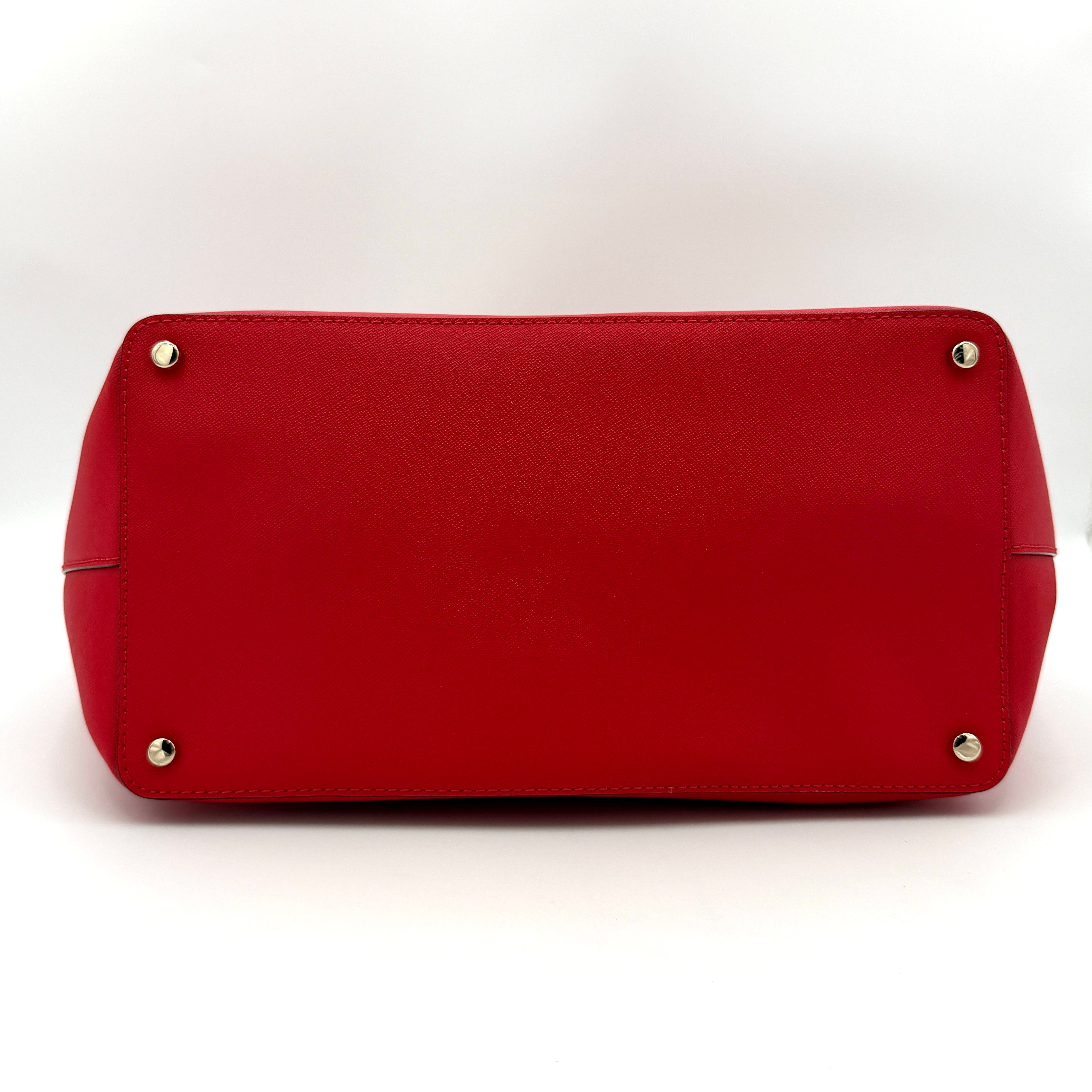 Kate Spade Cedar Street Harmony Tote bag in bold red saffiano leather, featuring dual top handles and gold-tone details.