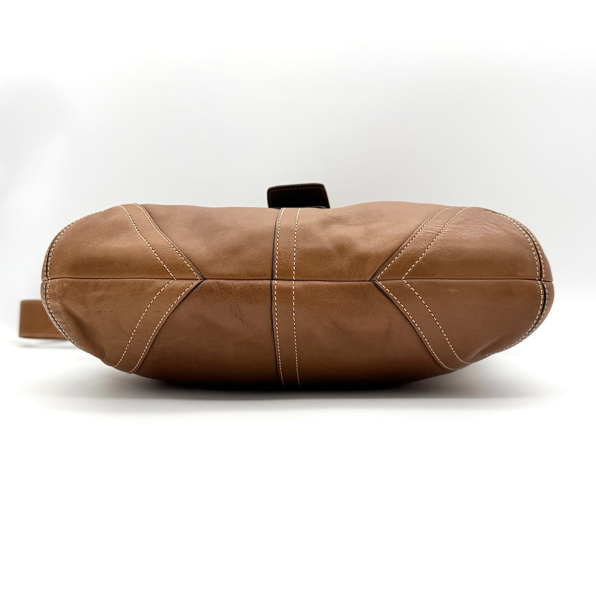 Coach Soho Buckle Flap Crossbody Bag in brown leather with buckle flap and adjustable strap, displayed on white background.