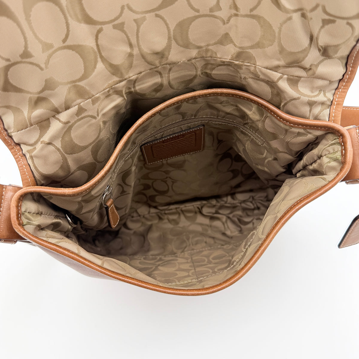 Coach Soho Buckle Flap Crossbody Bag in brown leather with buckle flap and adjustable strap, displayed on white background.