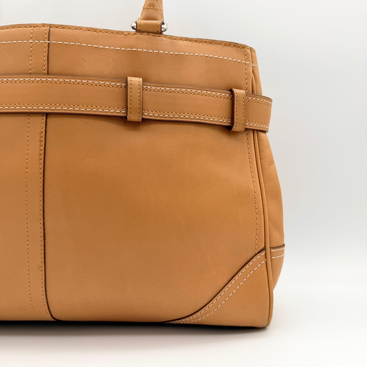 Coach Hampton Carryall in caramel brown leather with silver hardware and double handles, photographed against a white backdrop.